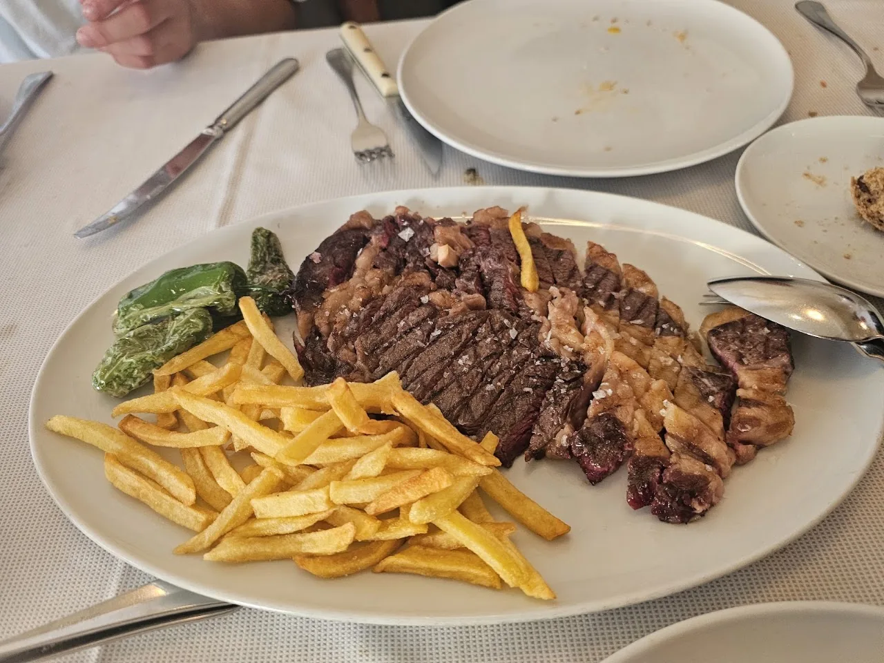 A grilled steak sliced with a side of French fries