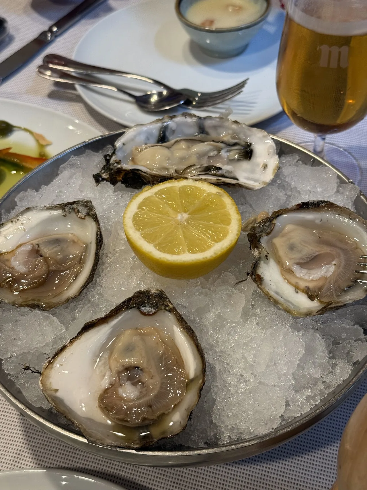A plate of oysters on ice with a lemon half