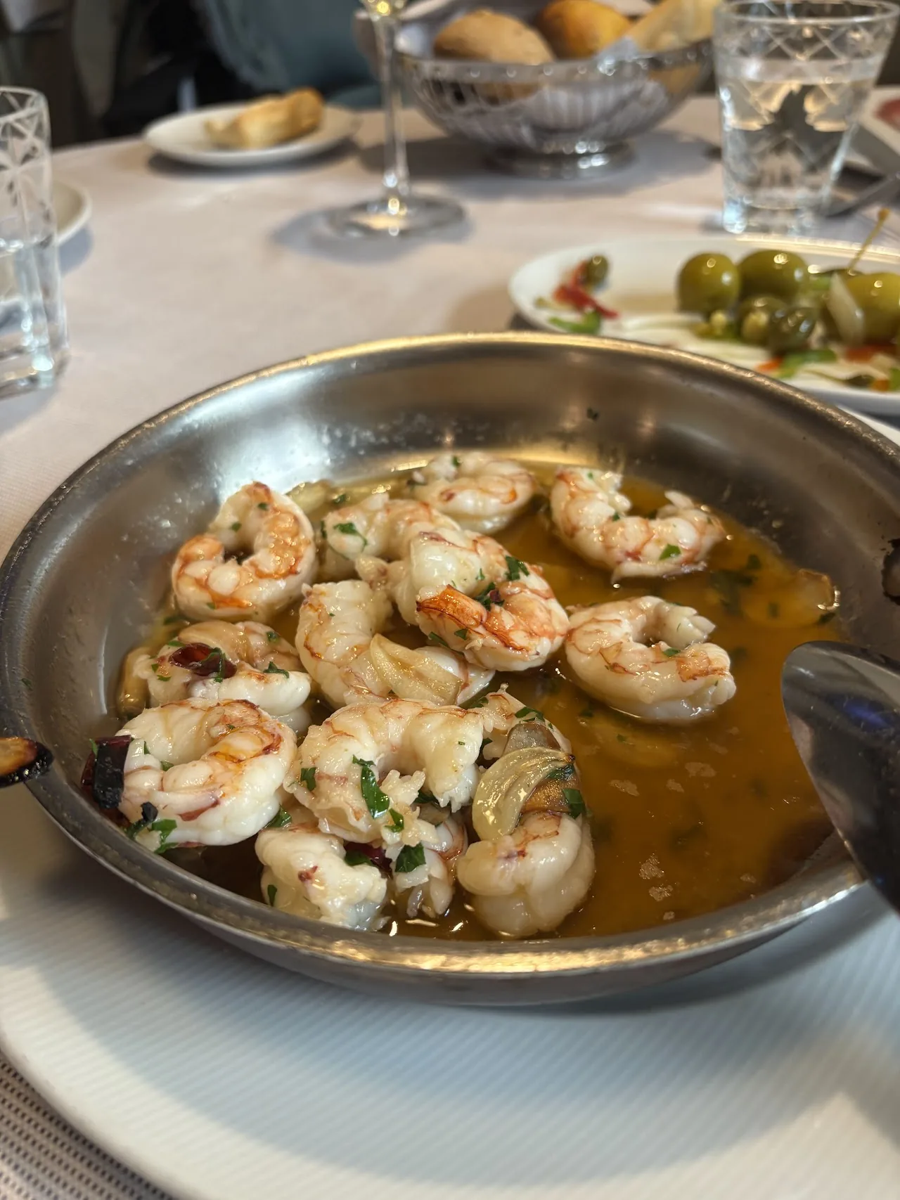 Shrimp cooked in garlic and olive oil in a metal pan