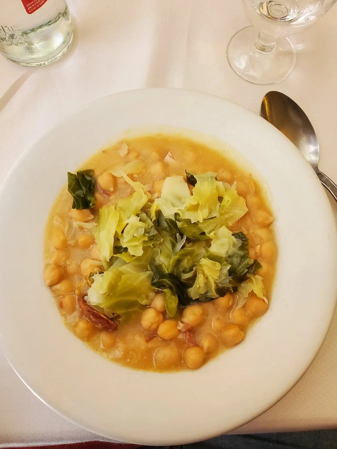 Chickpea and greens soup in a white bowl