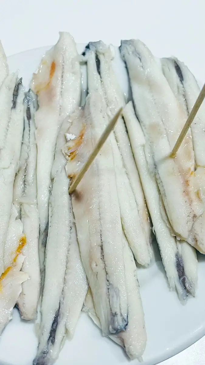 Plate of cured white anchovy fillets (boquerones) speared with toothpicks
