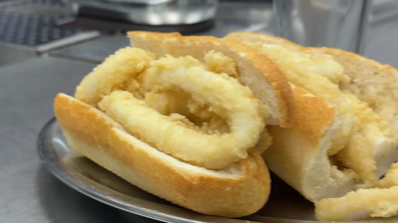 A fried calamari ring sandwich on a plate