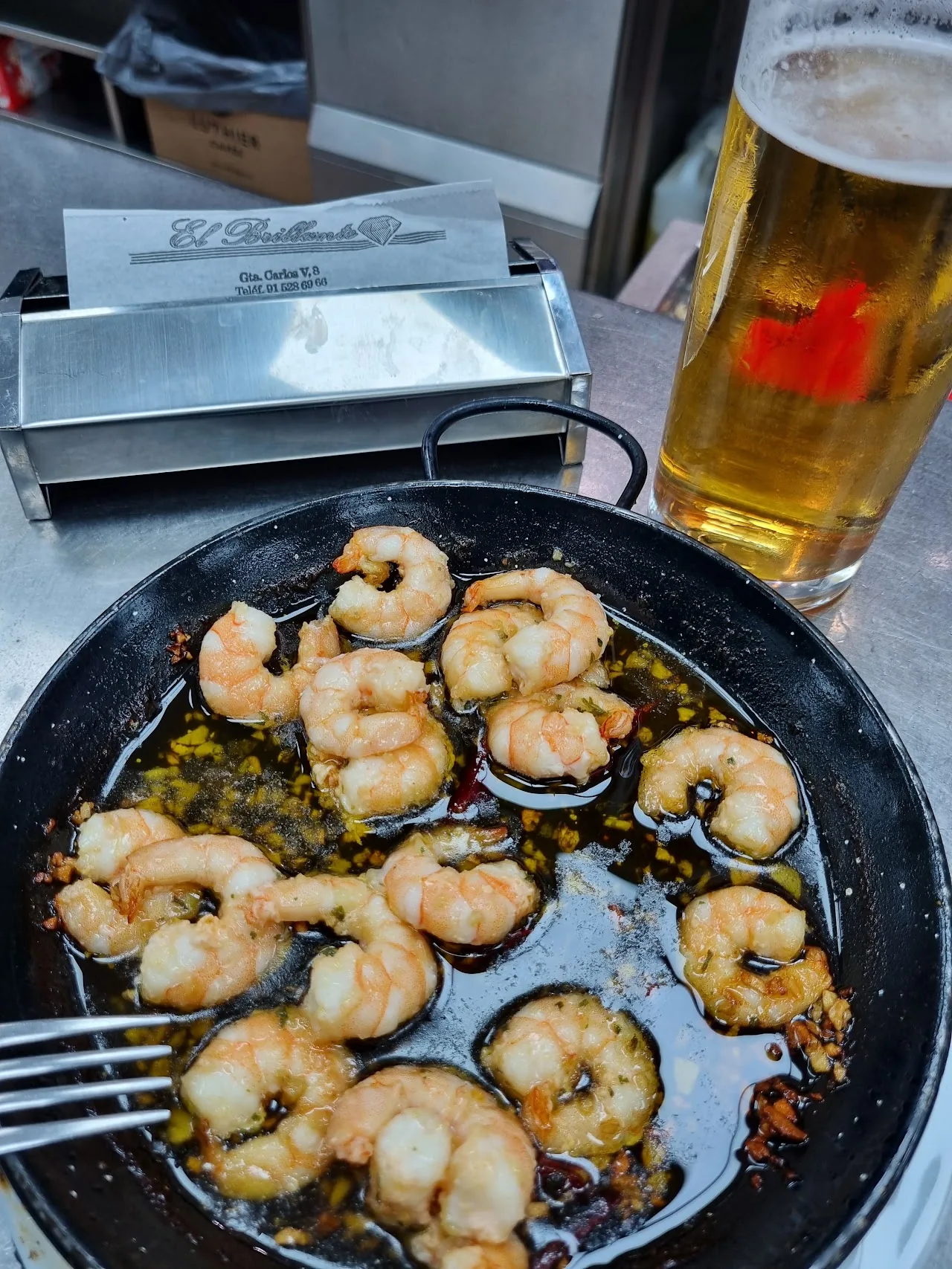 Garlic shrimp sizzling in a small metal pan
