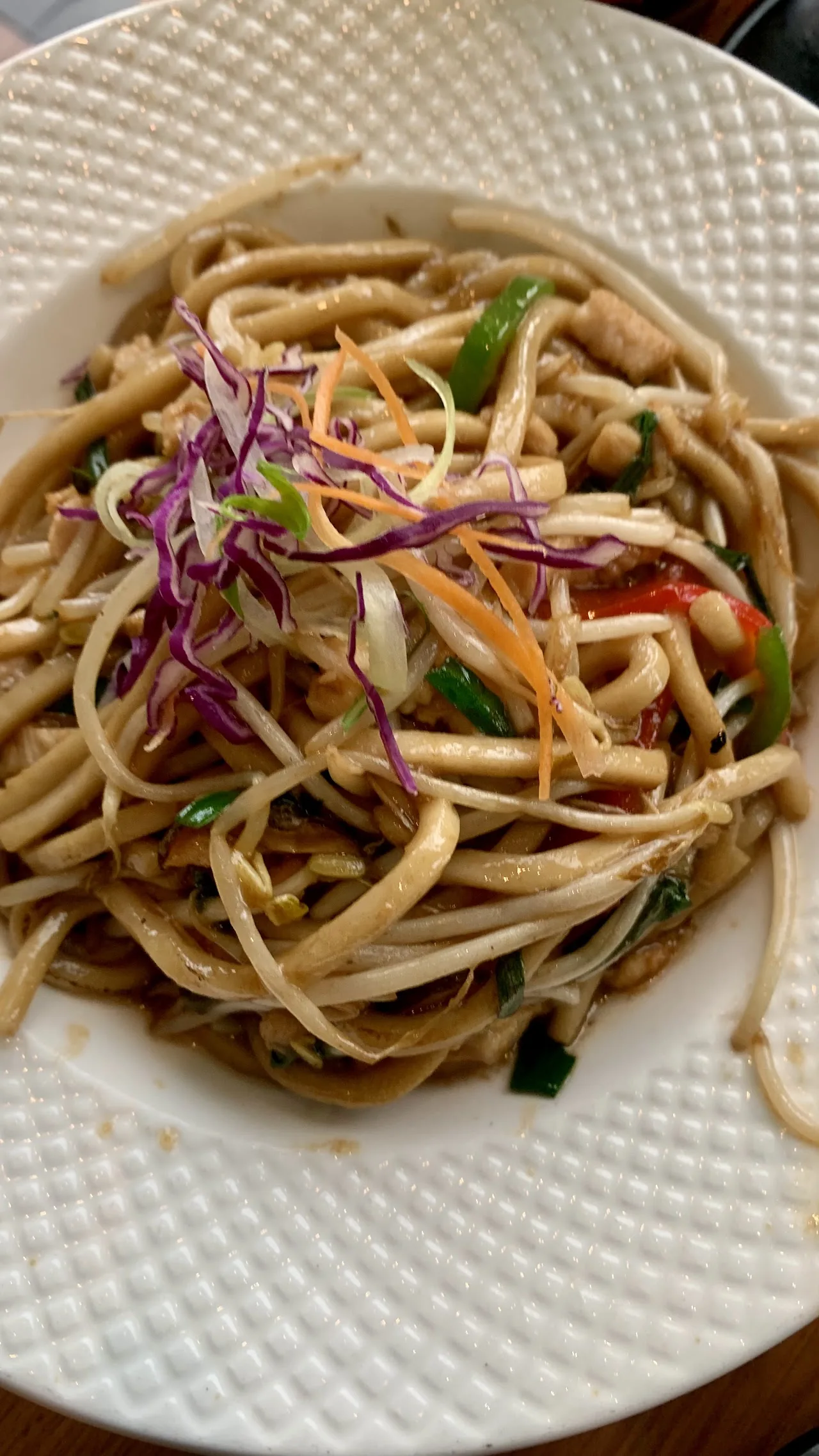A plate of stir-fried noodles with vegetables