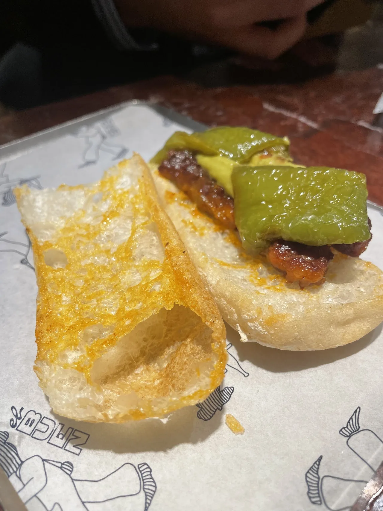 A folded sandwich with melted cheese and green pepper, served with crisps