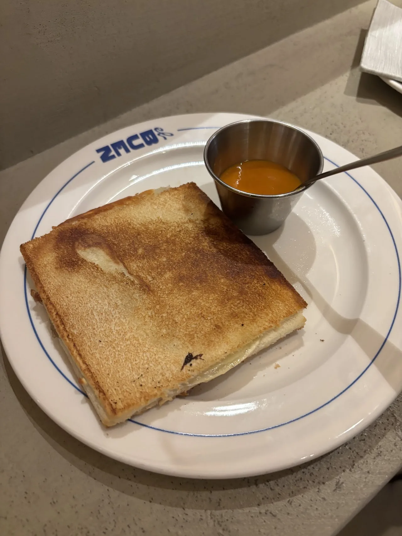 A grilled cheese toast sandwich with a side of dipping sauce