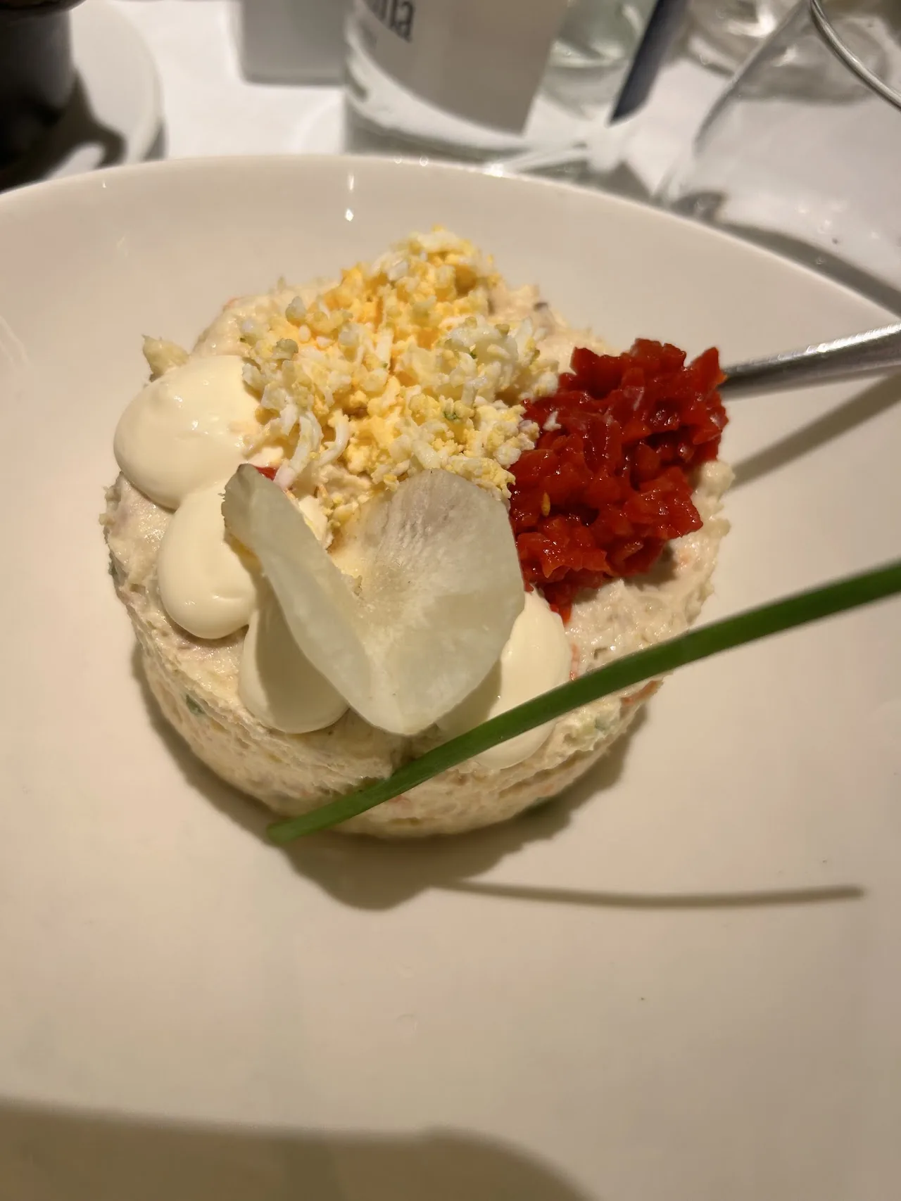 A small dish of popcorn, cheese, and diced red pepper