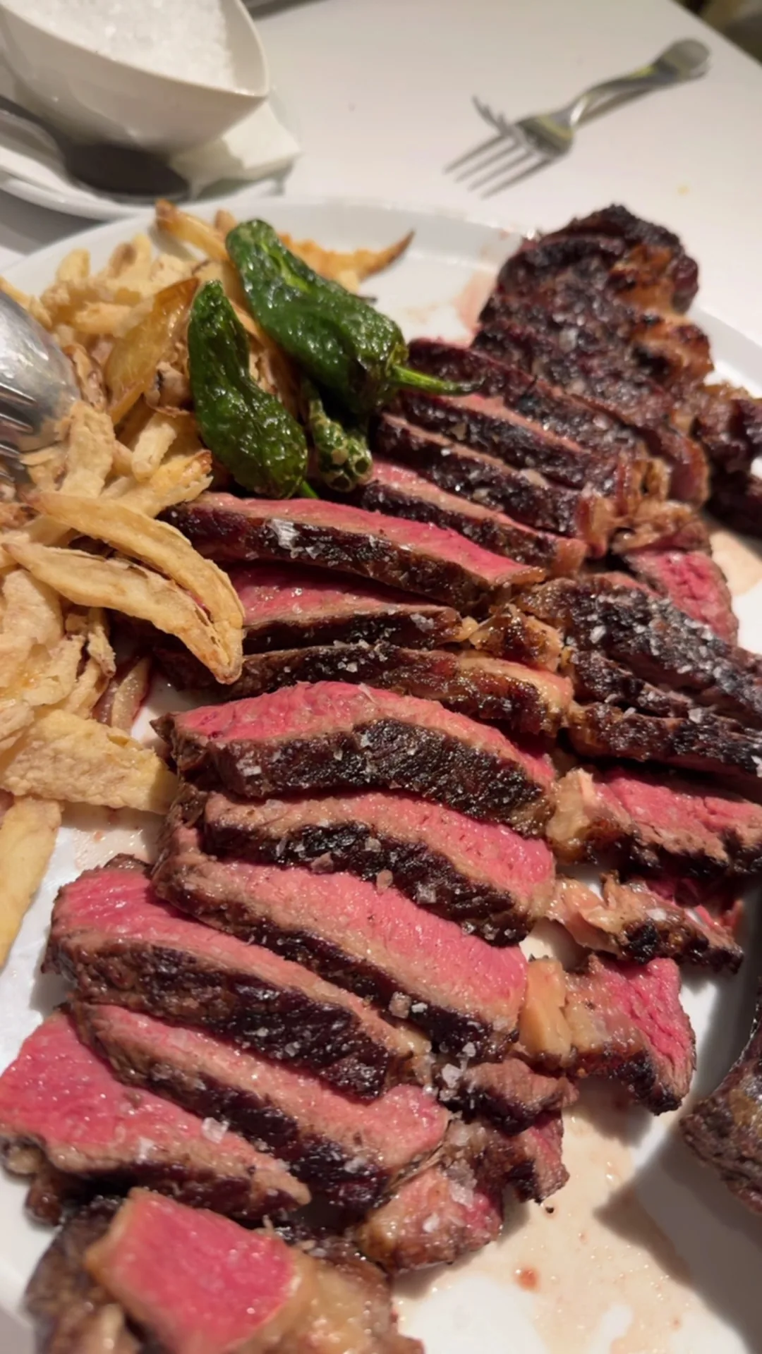 Sliced steak with charred onions on a plate