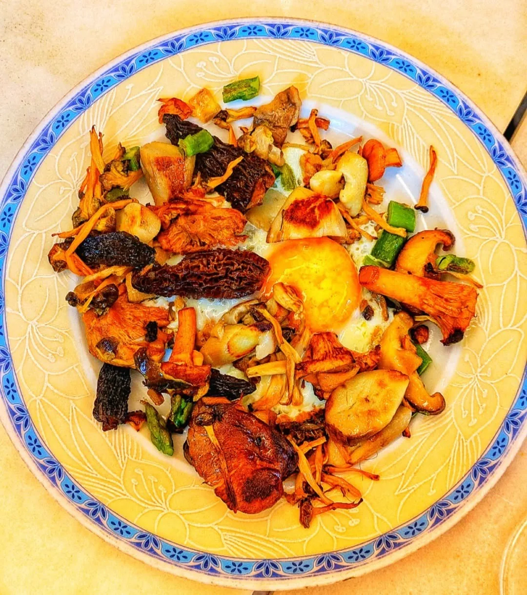 A blue-rimmed plate of colourful mushrooms and vegetables