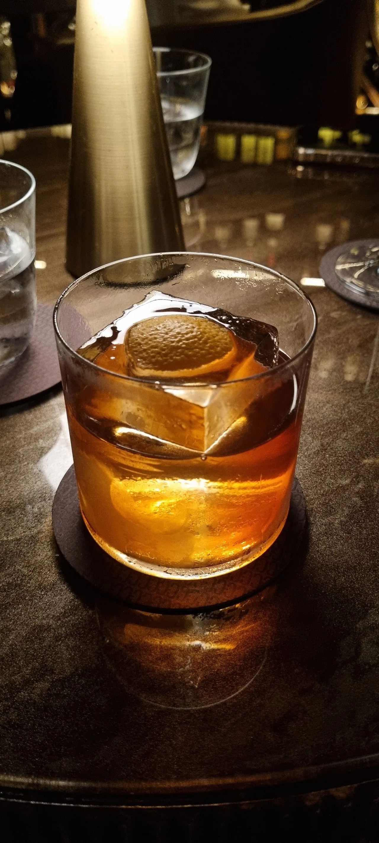 An old fashioned cocktail with a large ice cube