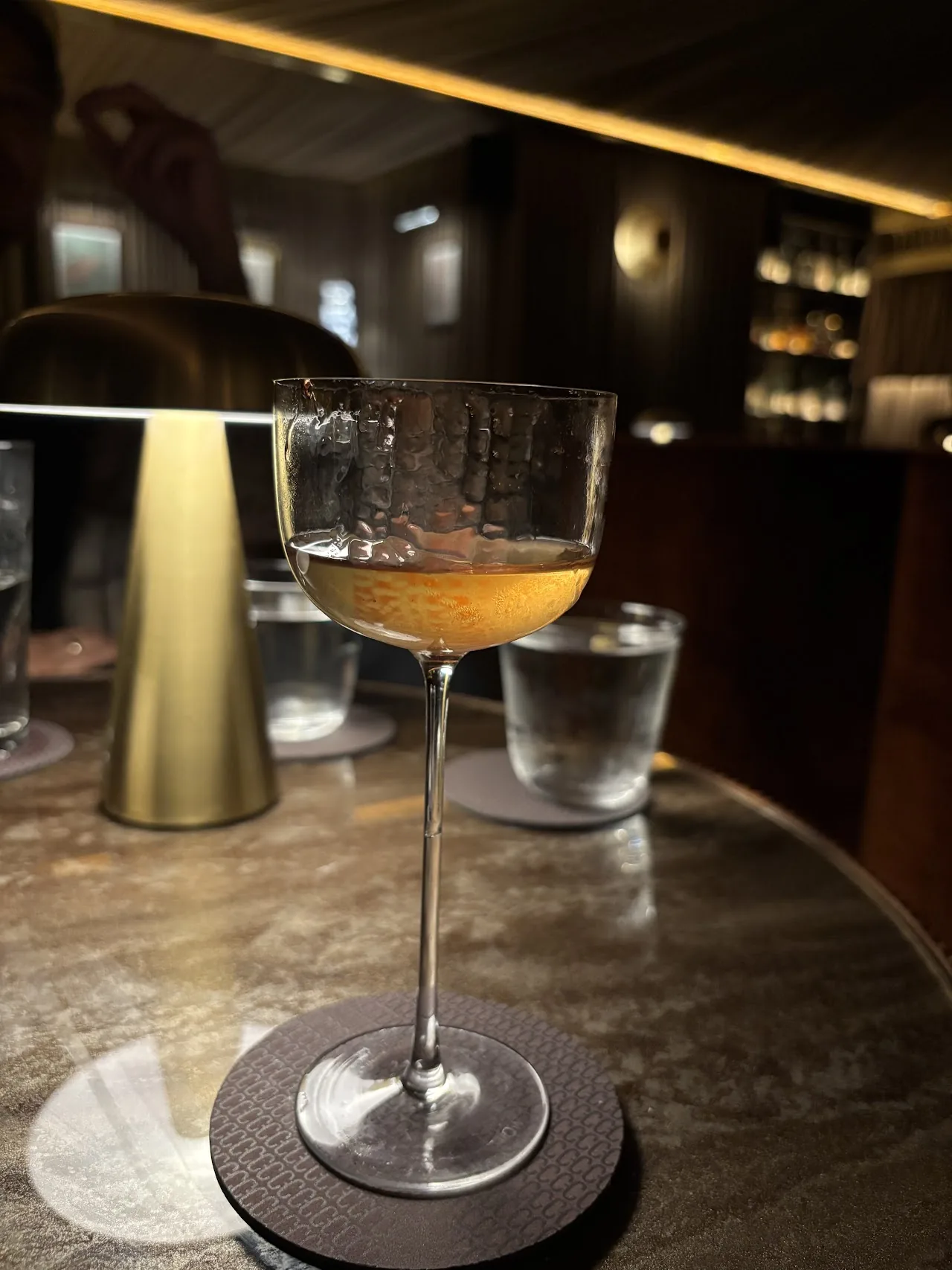 A cocktail in a coupe glass on a marble table