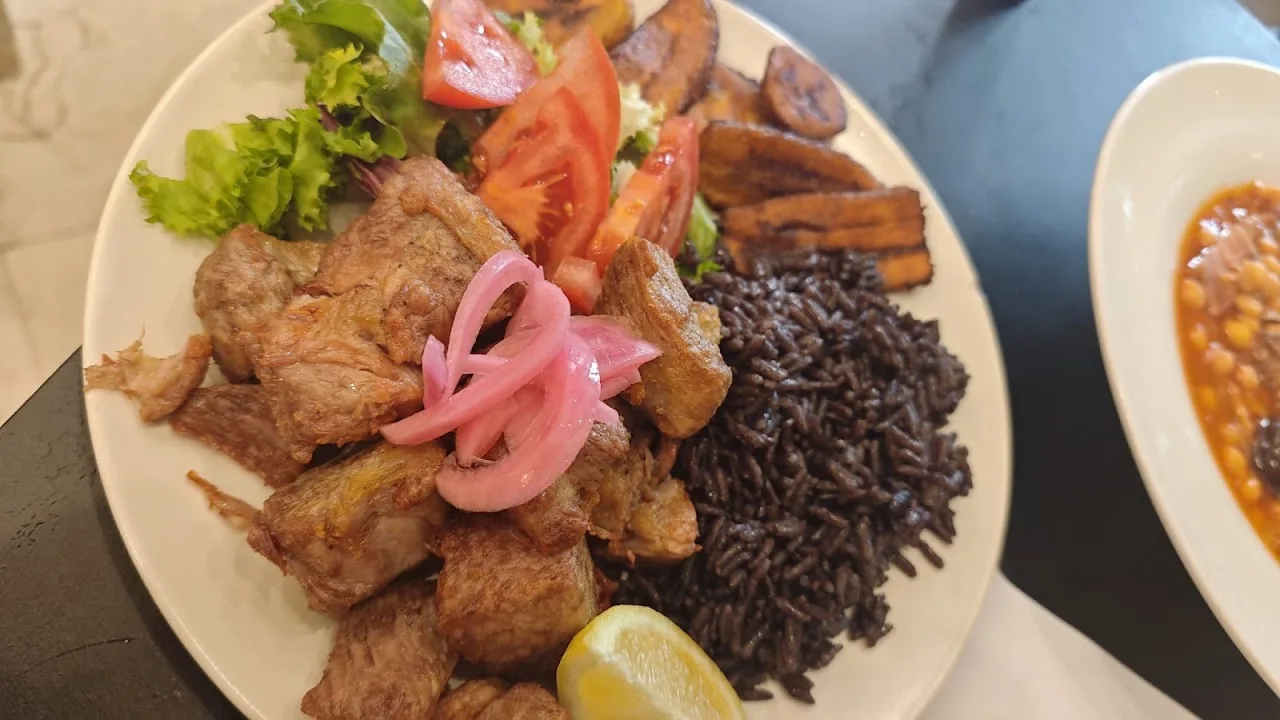 A plate of Cuban fried pork with black beans and plantain