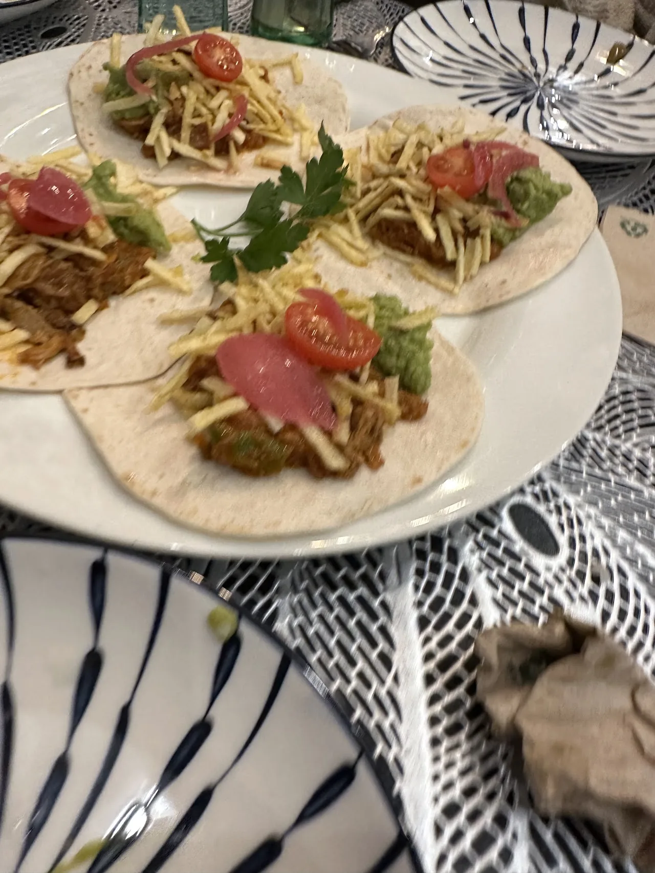 Fish tacos on a plate with tomato and greens
