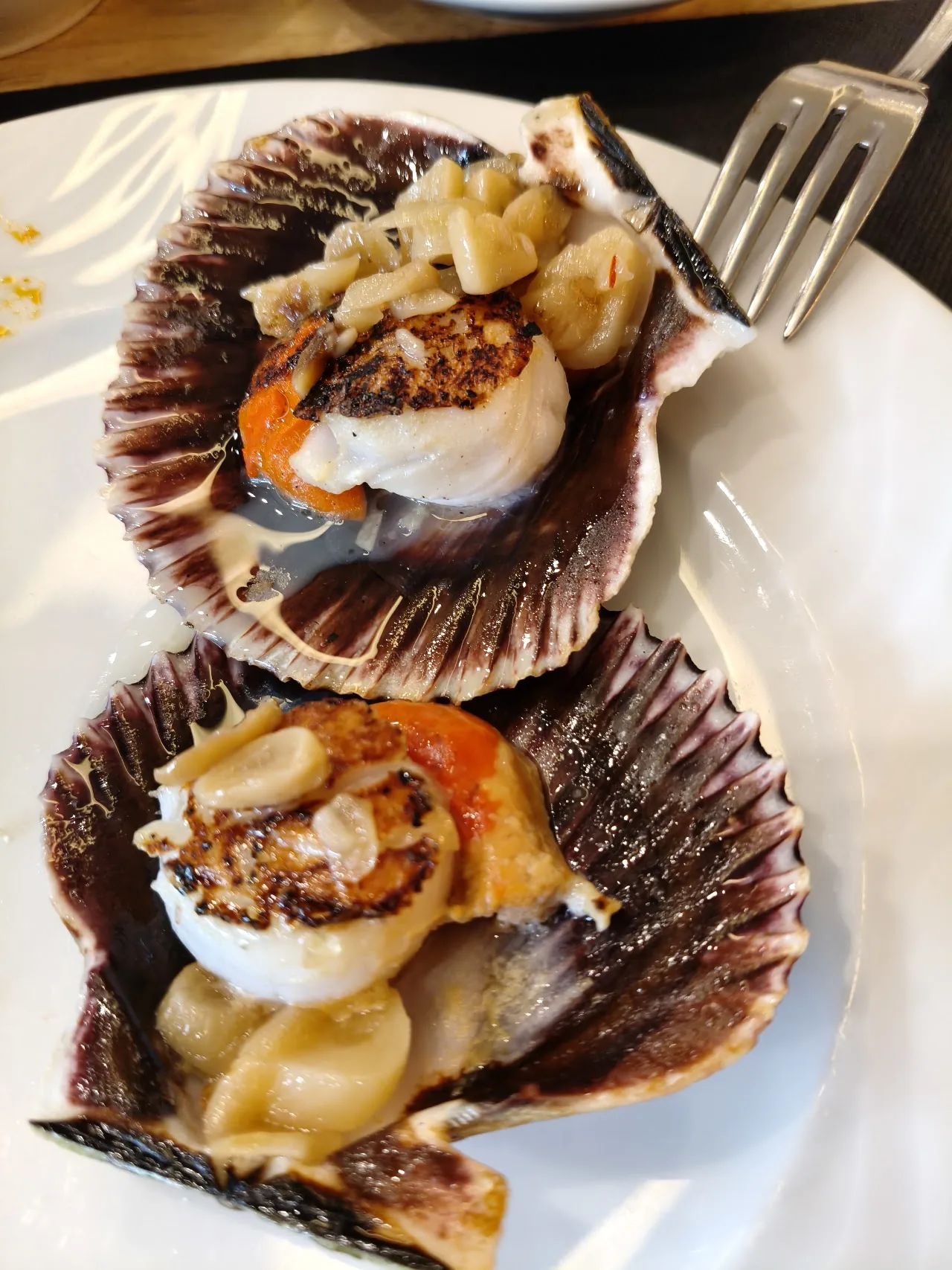 Two scallops served in their shells with breadcrumb topping
