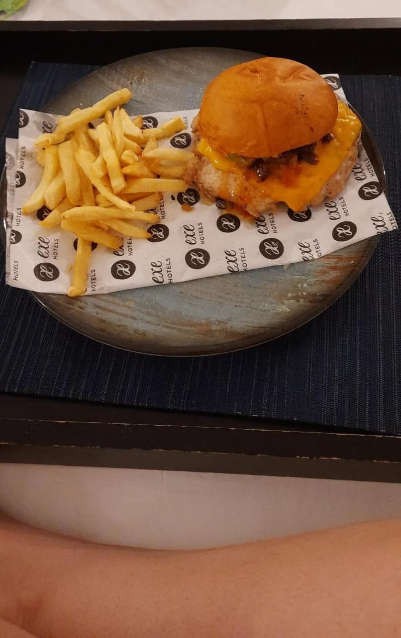 A burger and fries served in a wooden bowl