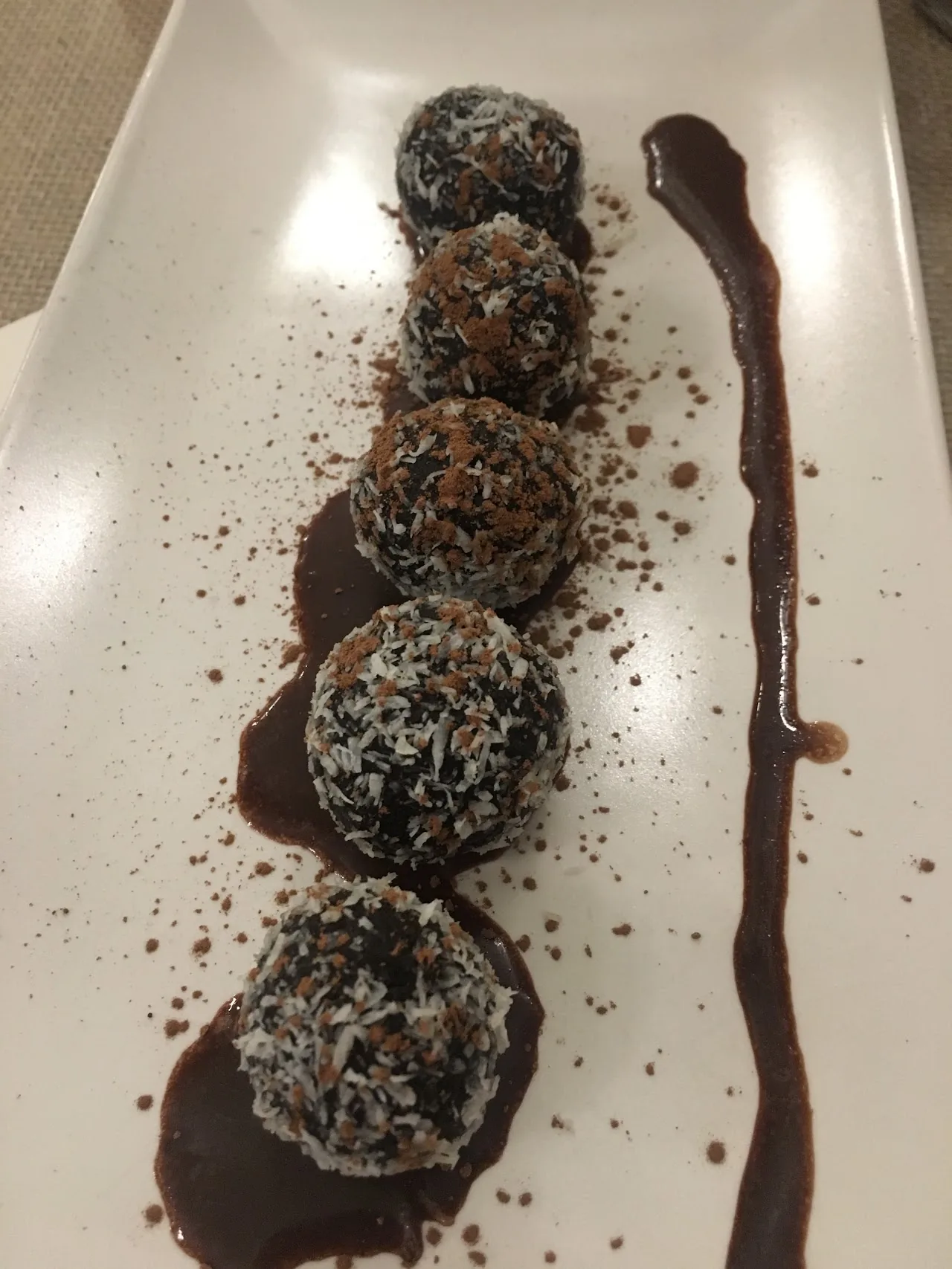 Chocolate-coated dessert balls drizzled with chocolate sauce