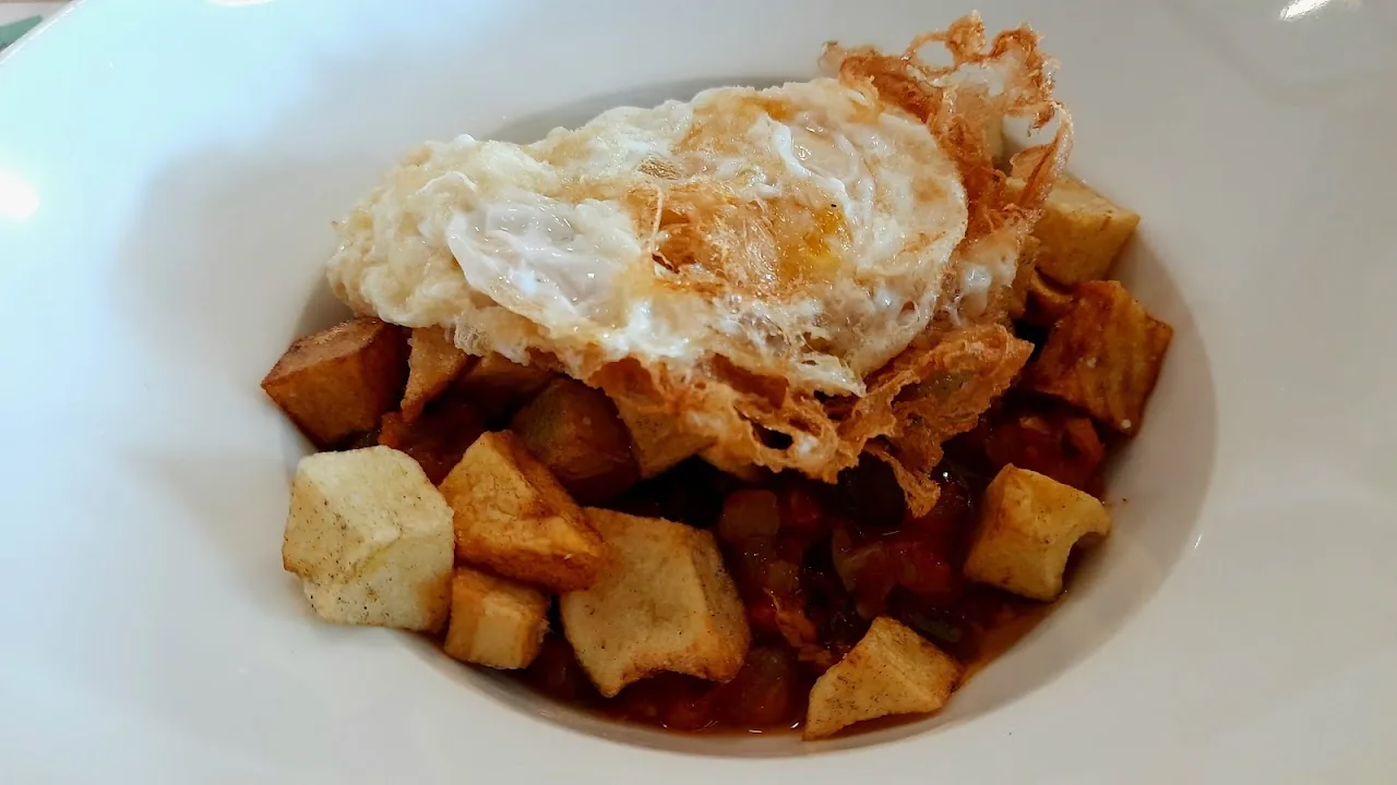 A fried egg served over diced potatoes