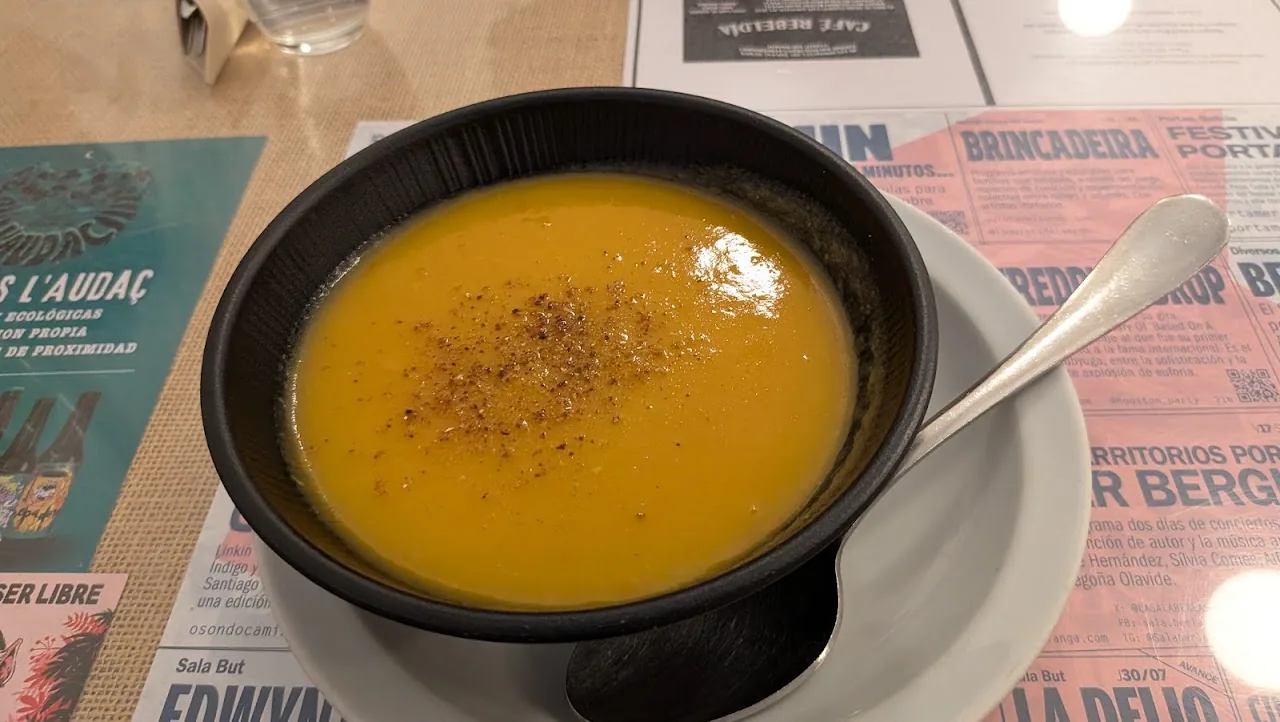 A bowl of orange pumpkin soup