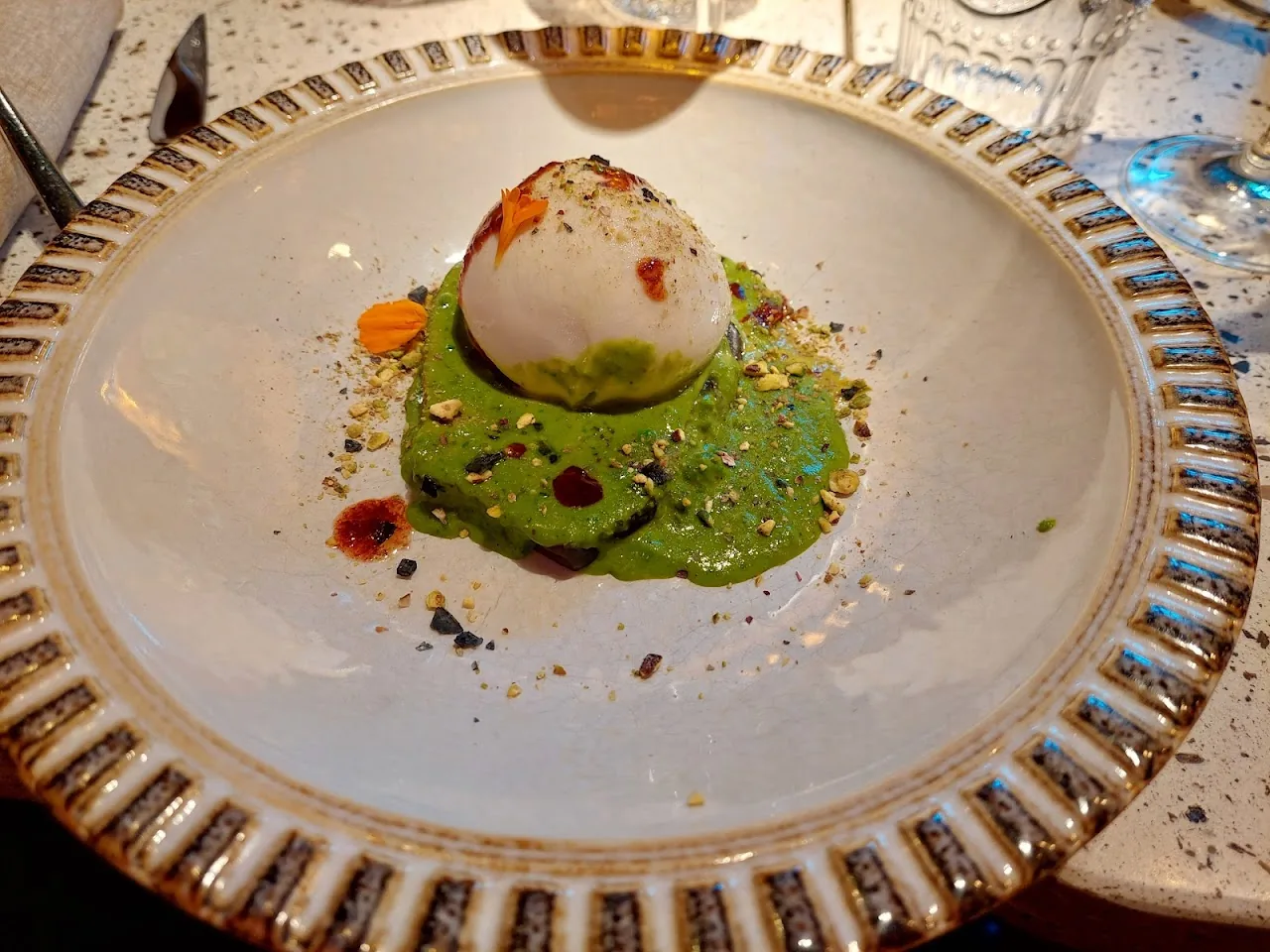 A poached egg over green avocado purée