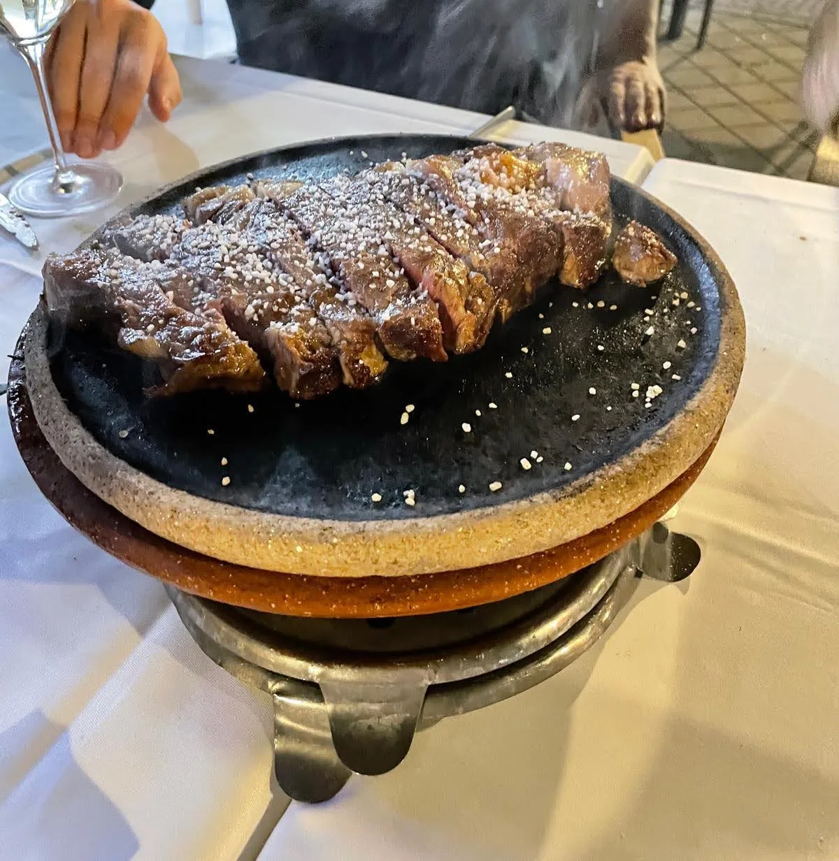 A steak served sizzling on a hot stone
