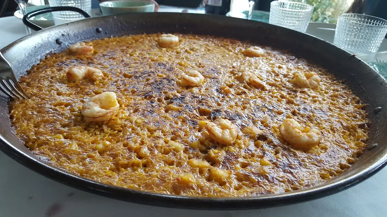 A paella pan of rice with shrimp and mussels
