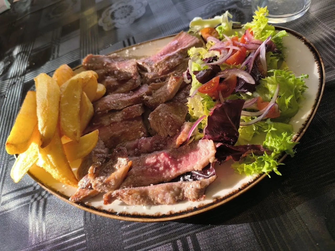 Grilled steak served with fries and salad
