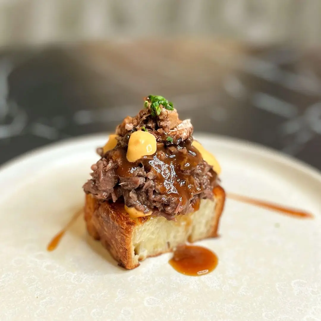 Toast topped with shredded braised meat, sauce and chives