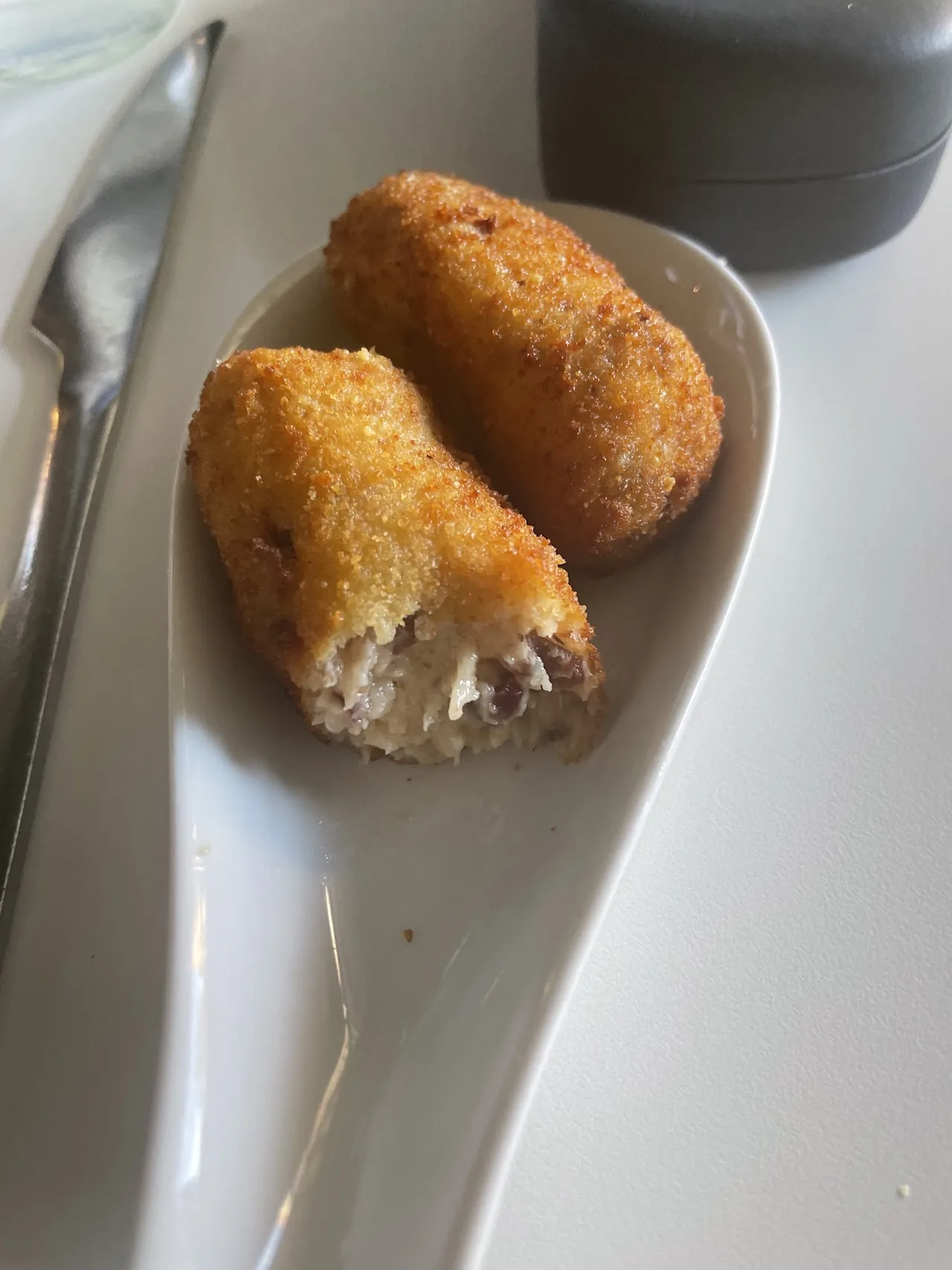 Two breaded croquettes on a plate