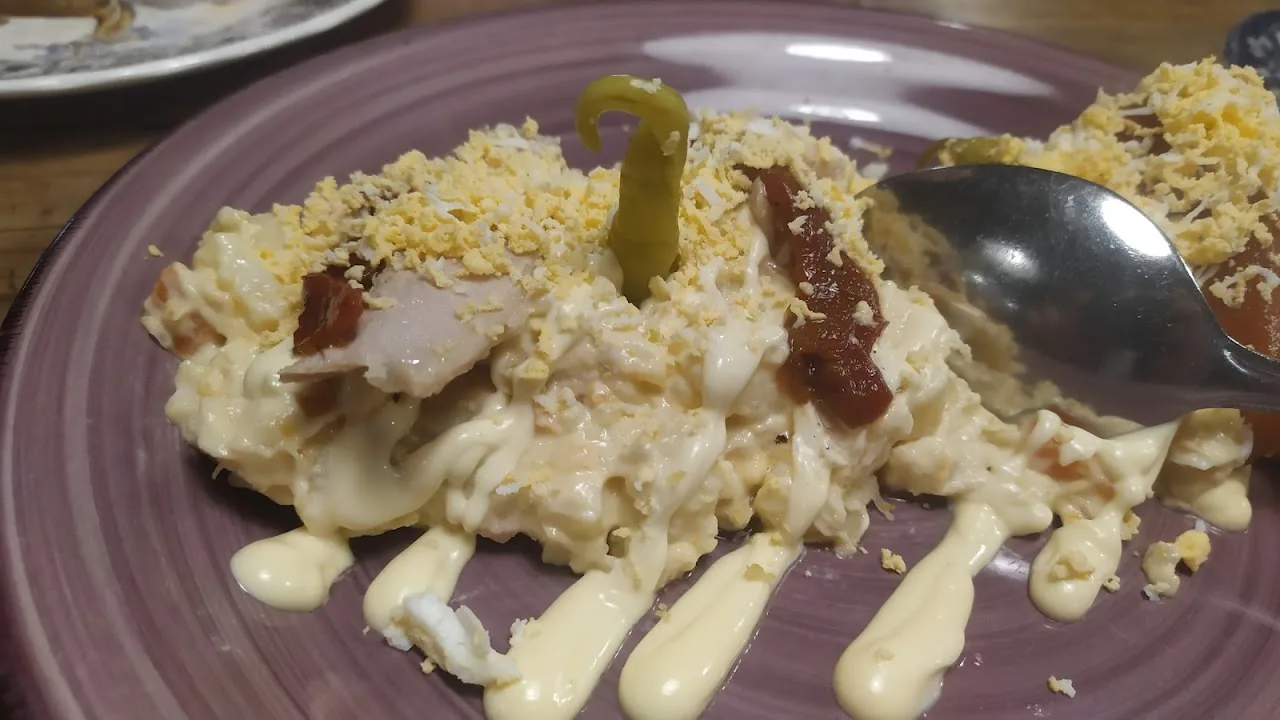 A creamy rice dish garnished with an olive