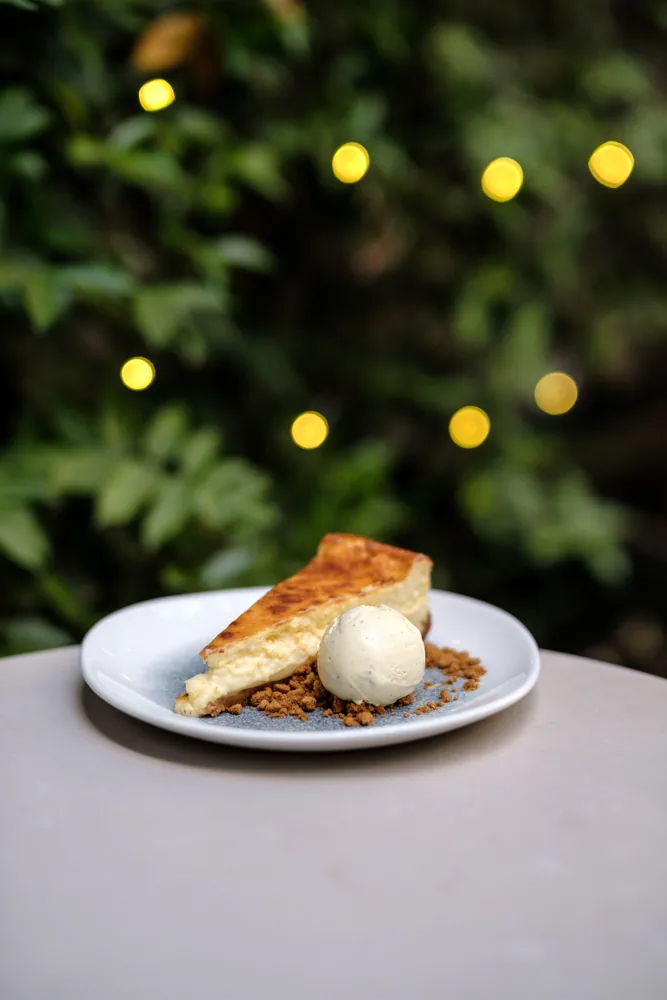 A dessert plate with a scoop of ice cream on a terrace table