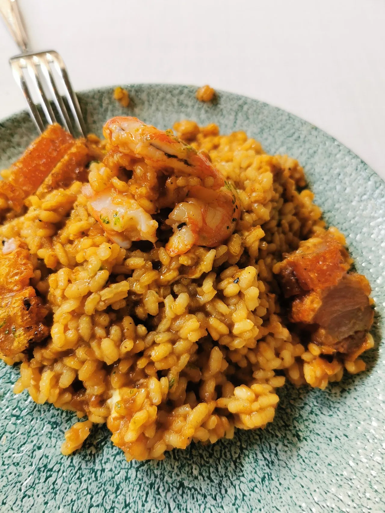 A plate of yellow rice with chicken and vegetables