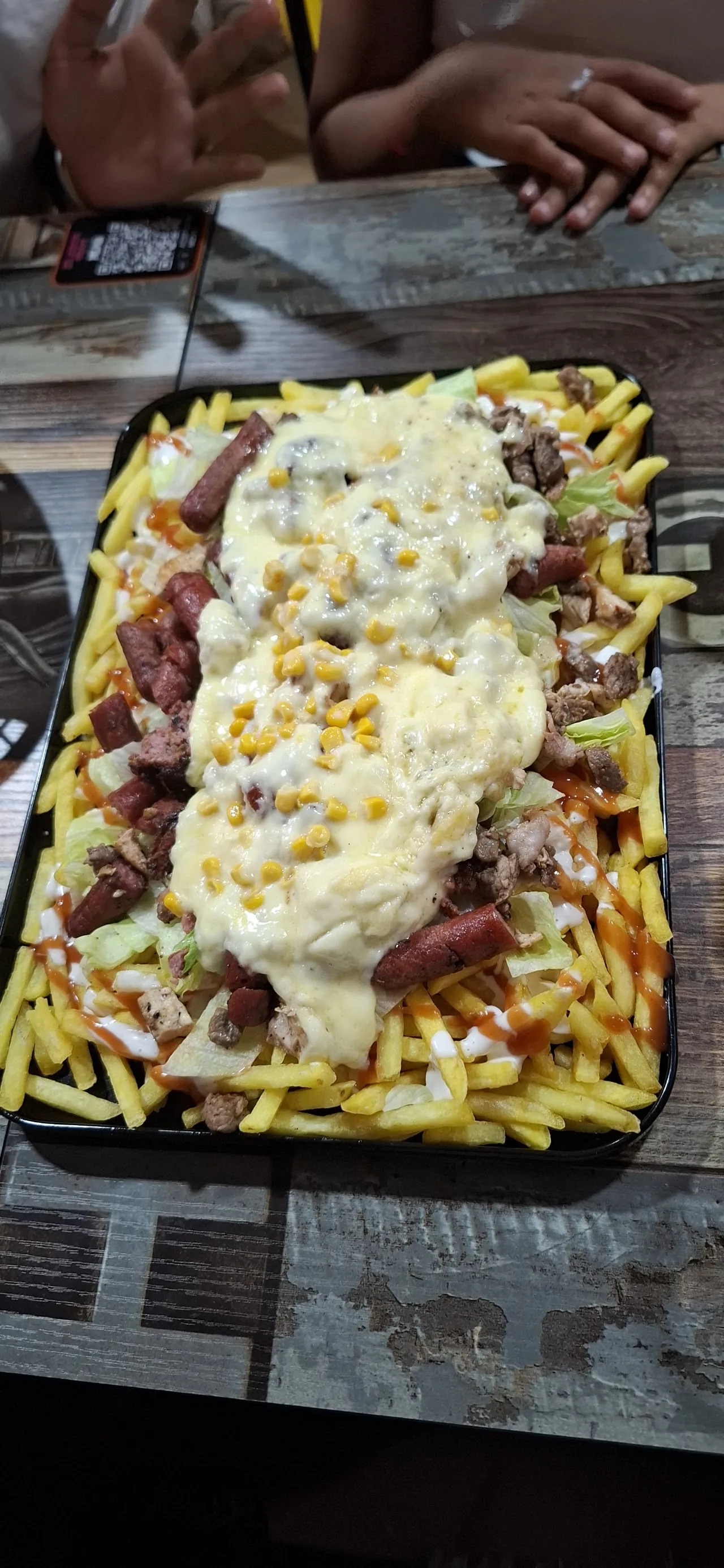 A tray of fries topped with melted cheese sauce
