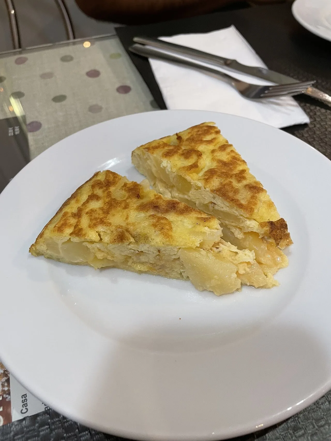A slice of potato omelette on a white plate
