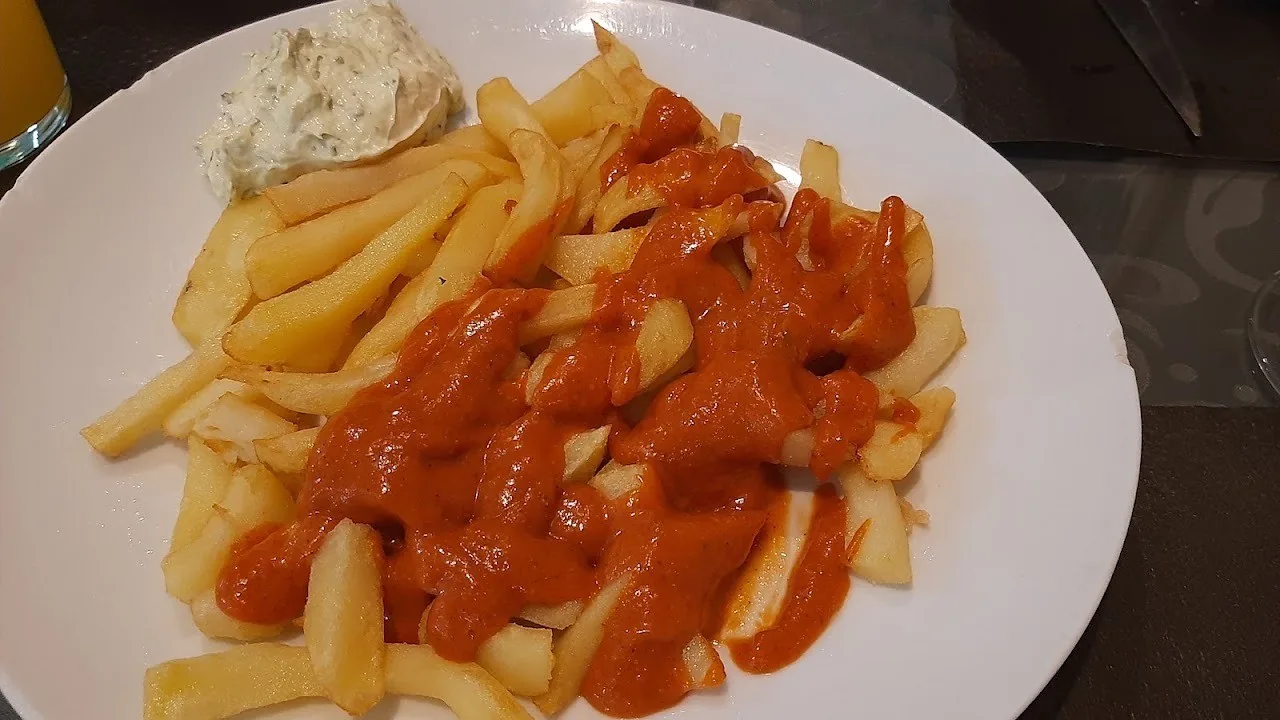 Fries with a red sauce on a white plate