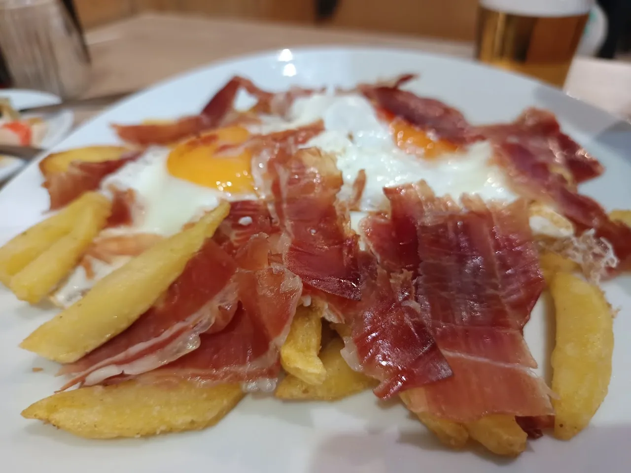 Fried eggs with cured ham and fries