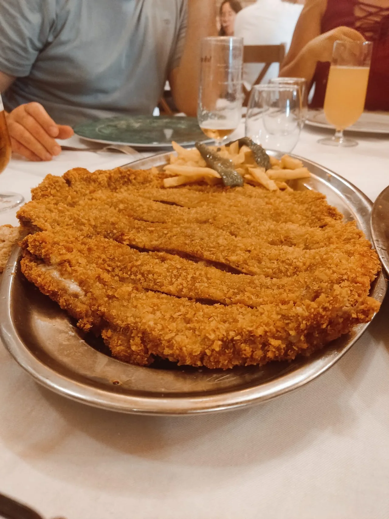 A giant breaded veal cutlet (cachopo) filling a large plate