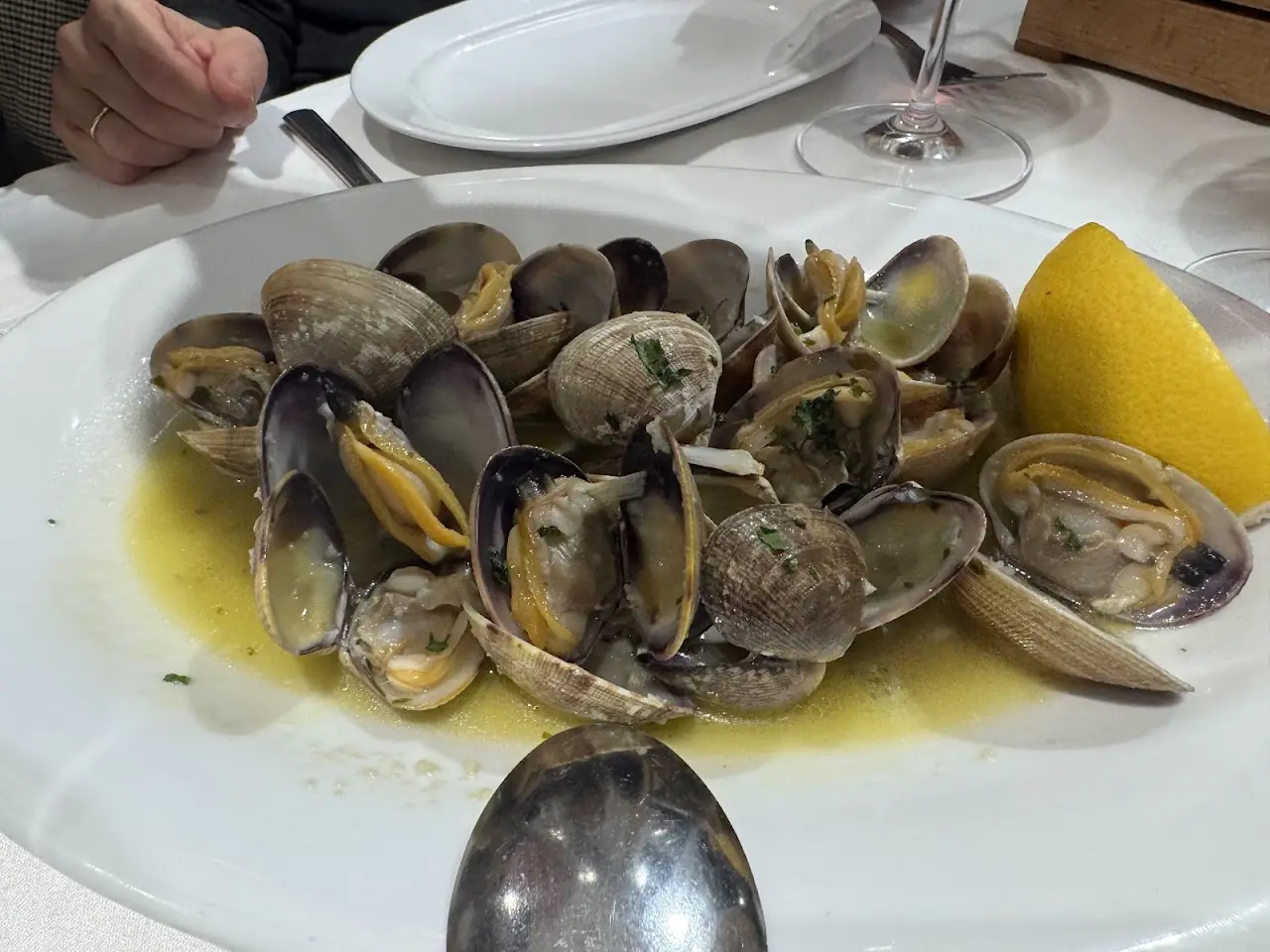 Clams in a garlic and white wine sauce with a lemon wedge