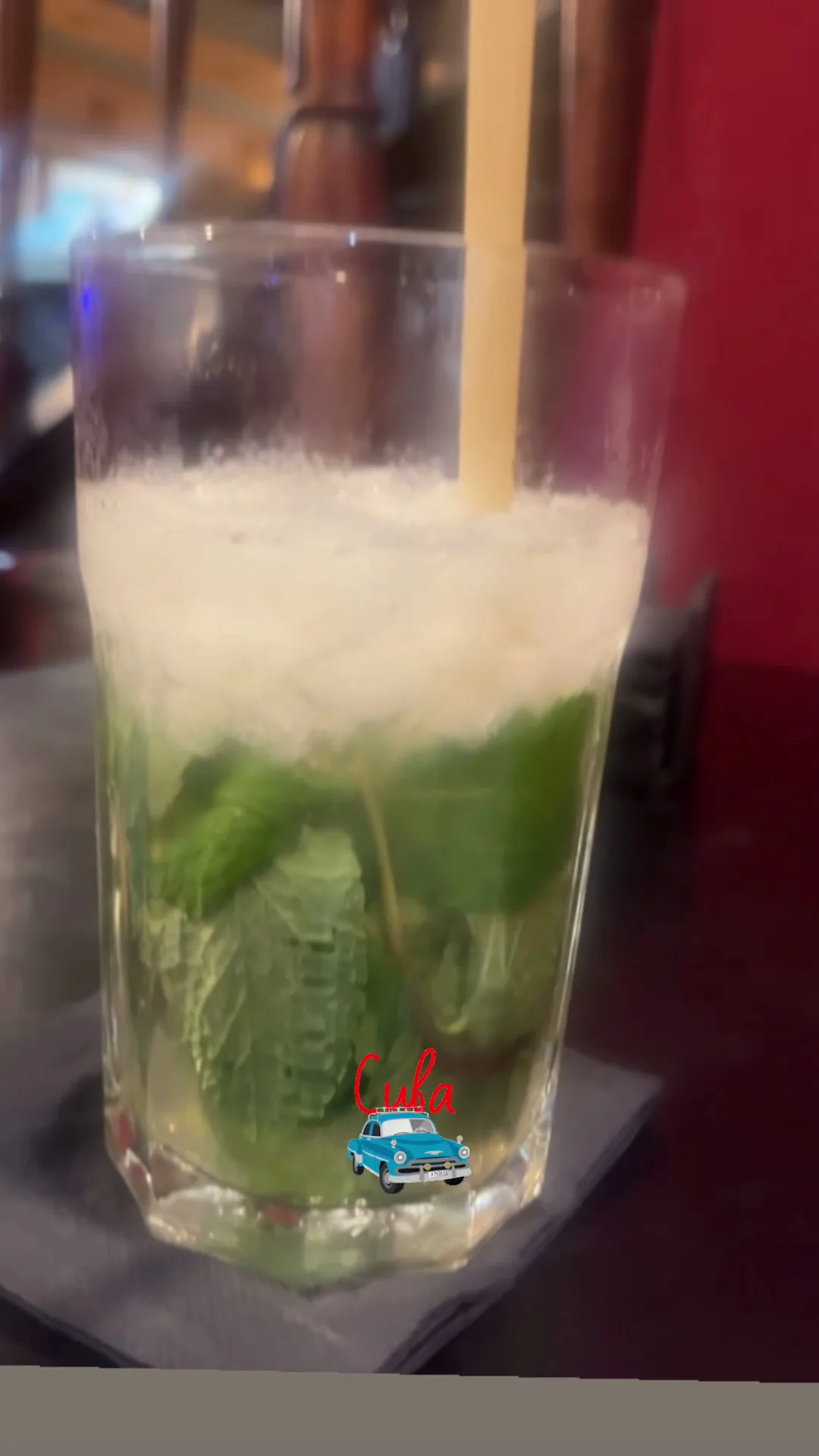 A mojito cocktail with mint leaves and a straw