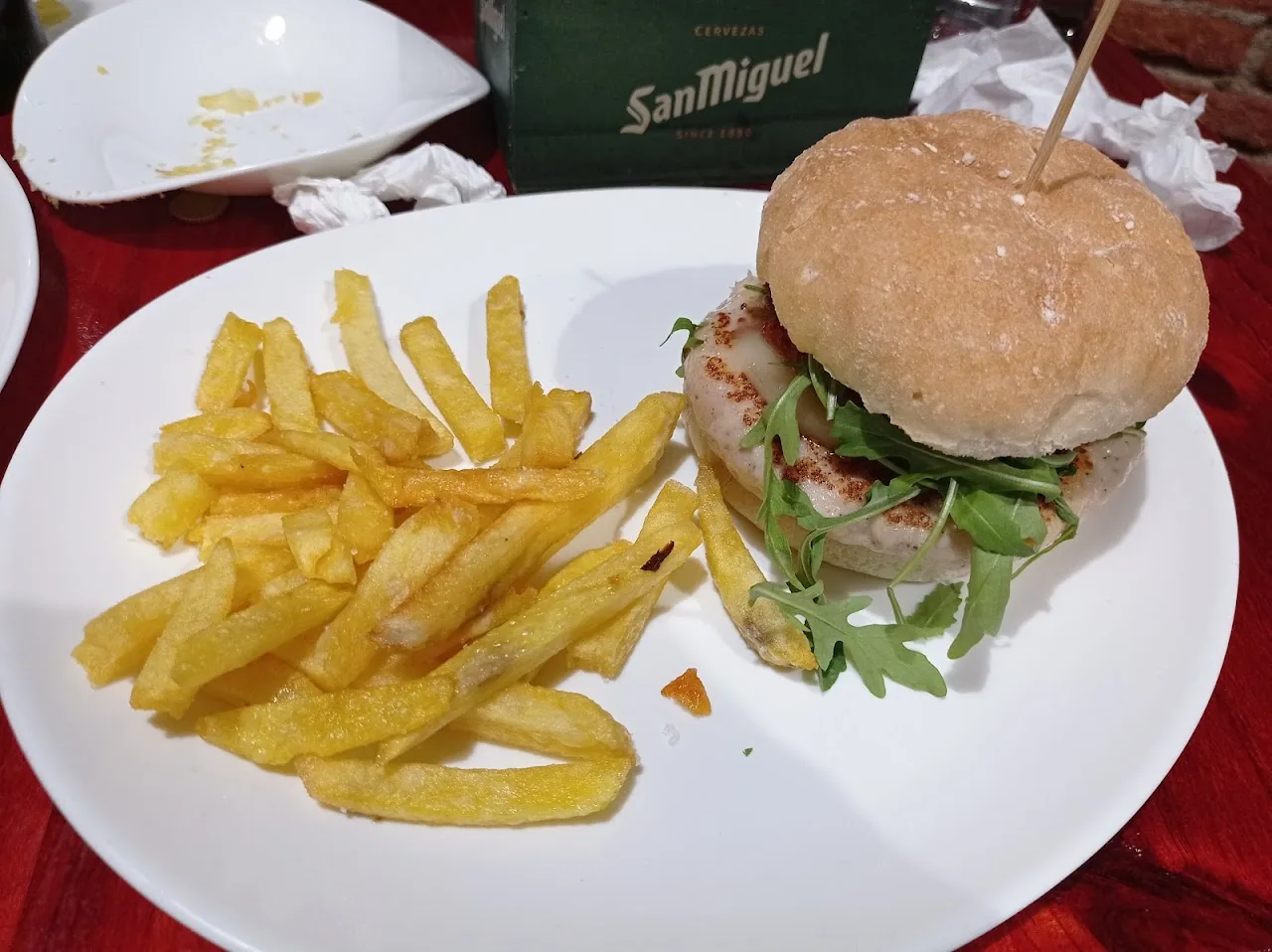 A burger and fries on a white plate