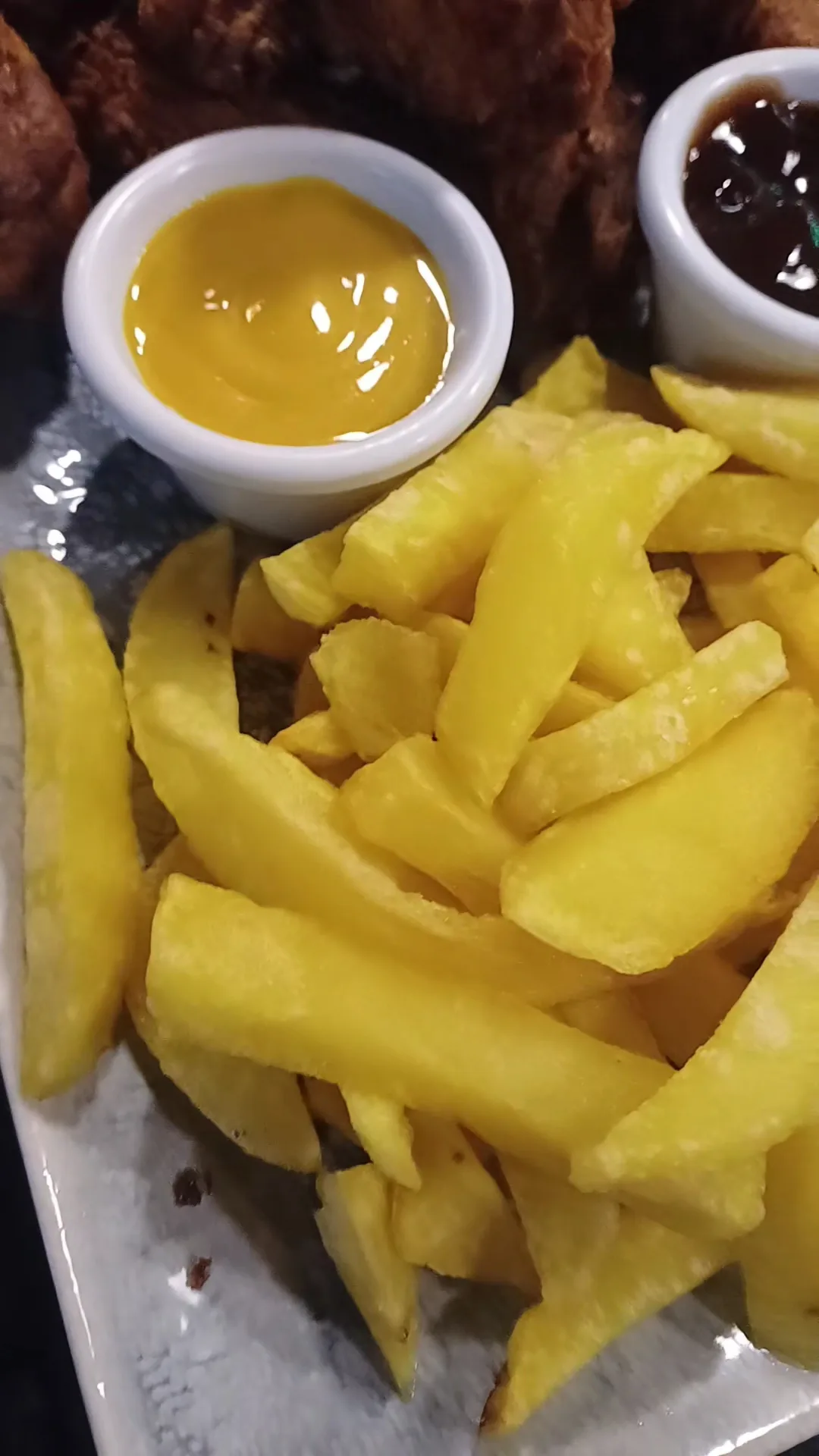 A basket of French fries with two dipping sauces