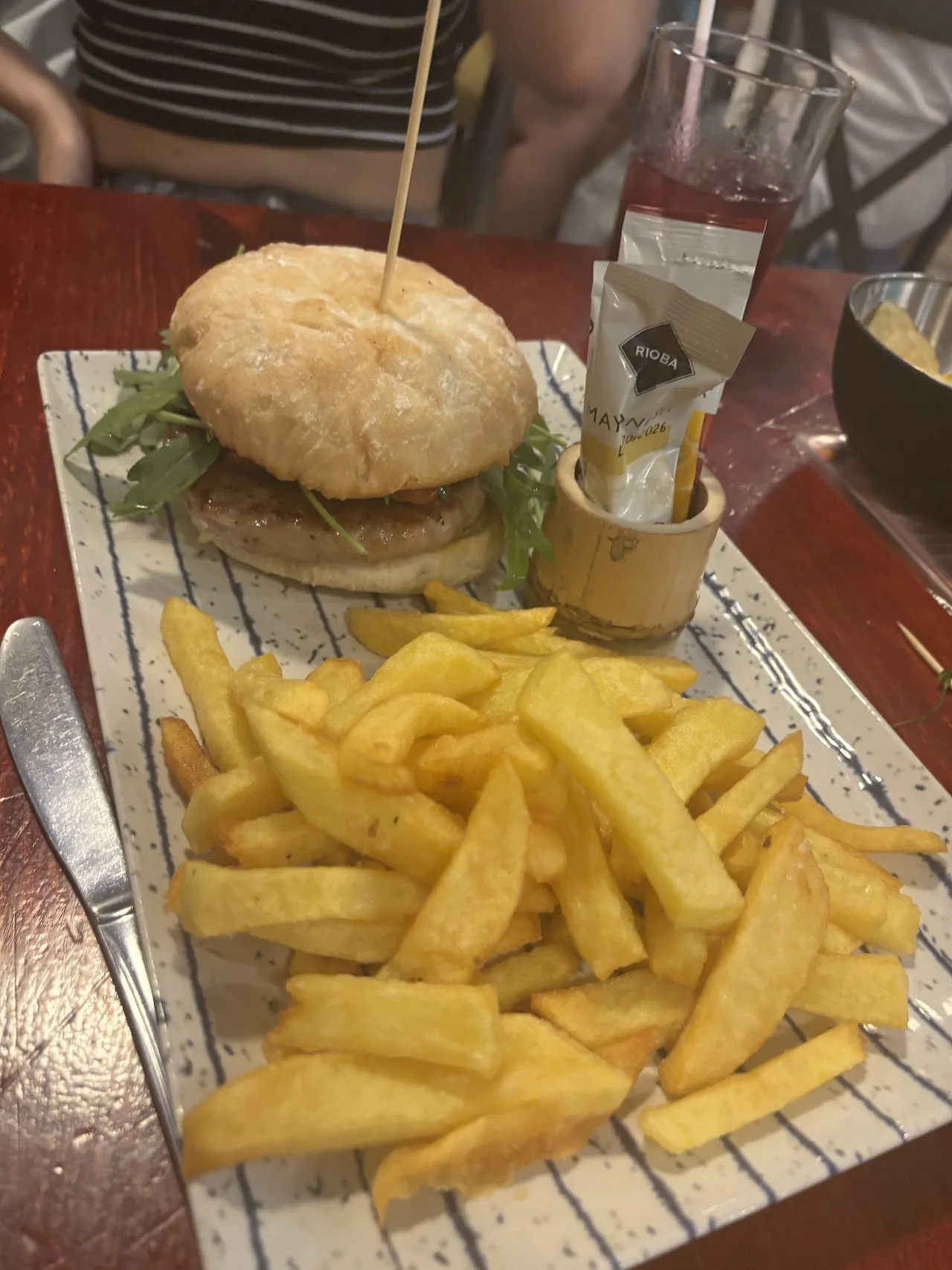 A mini burger skewer served with a side of fries