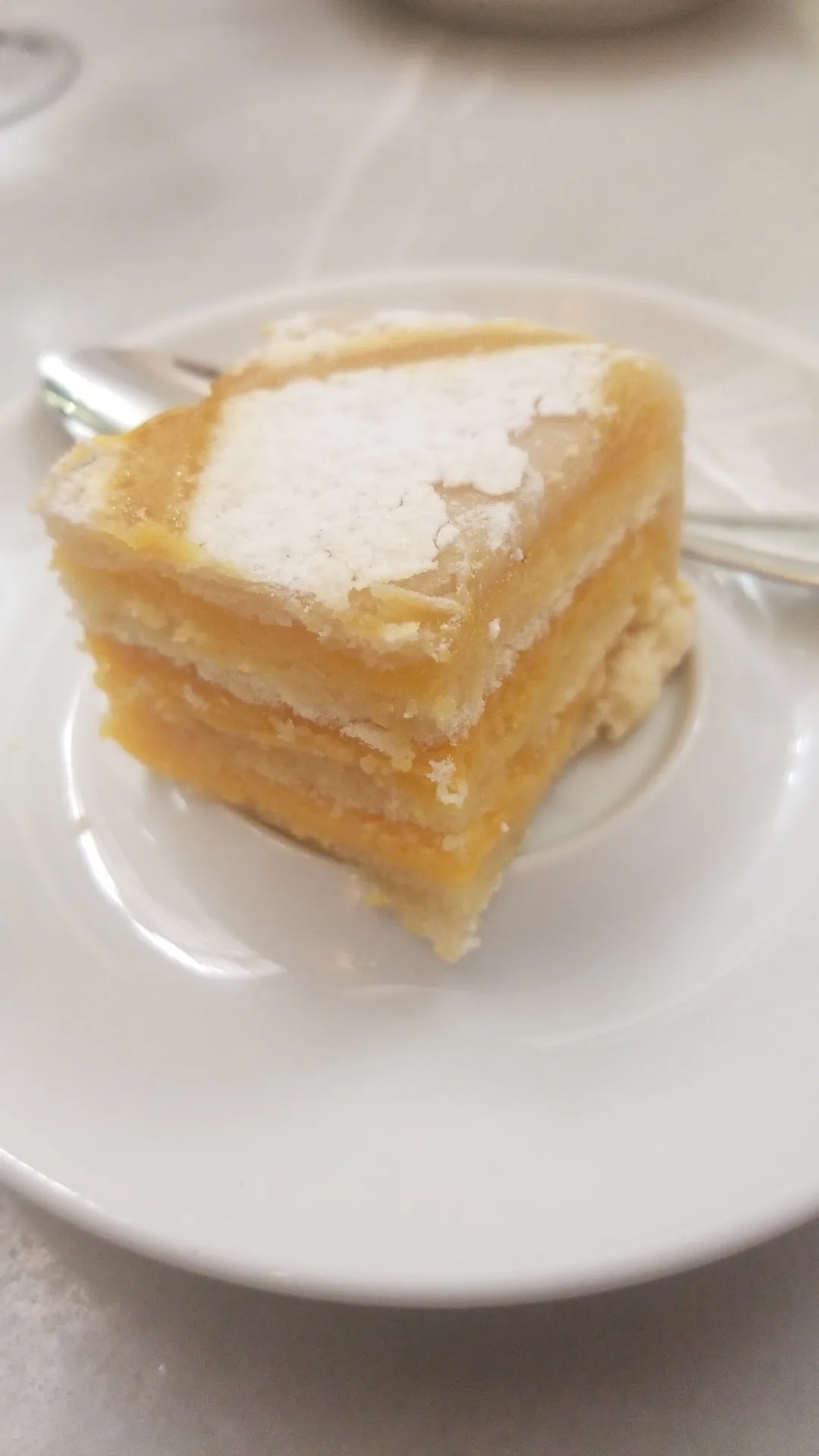 A slice of napoleon pastry dusted with powdered sugar