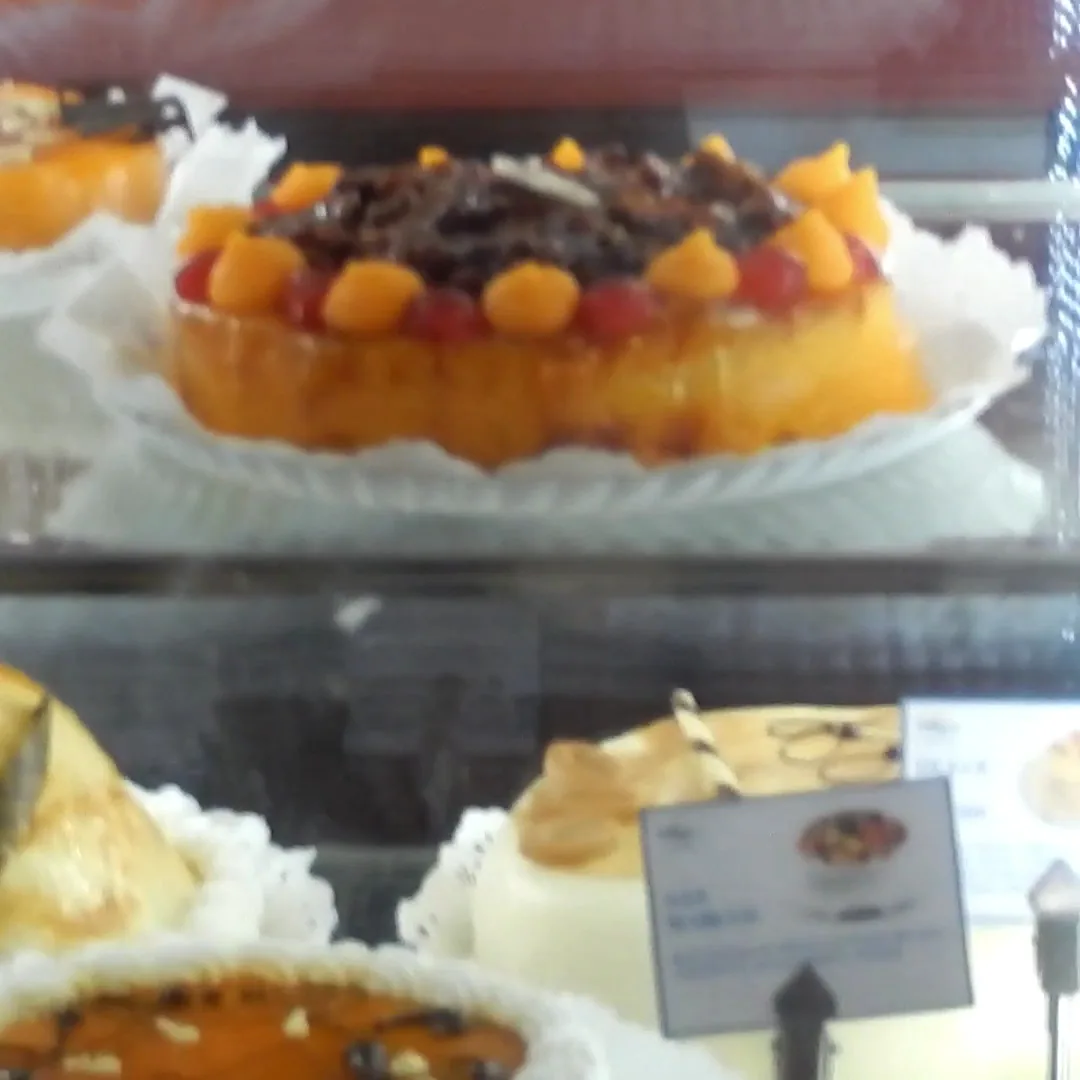 Custard tarts topped with fruit in a bakery display case