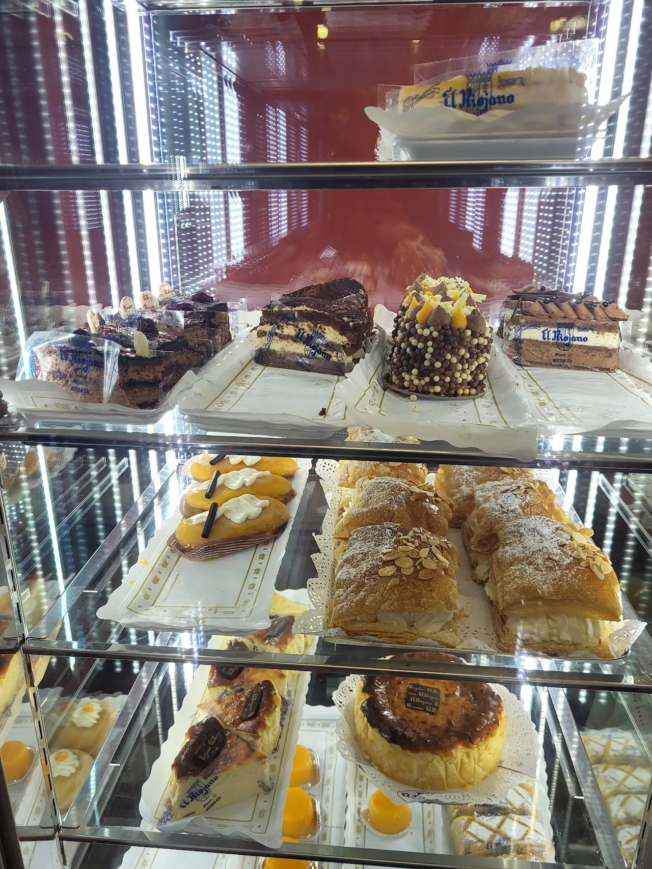 An assortment of pastries and cakes in a bakery display case