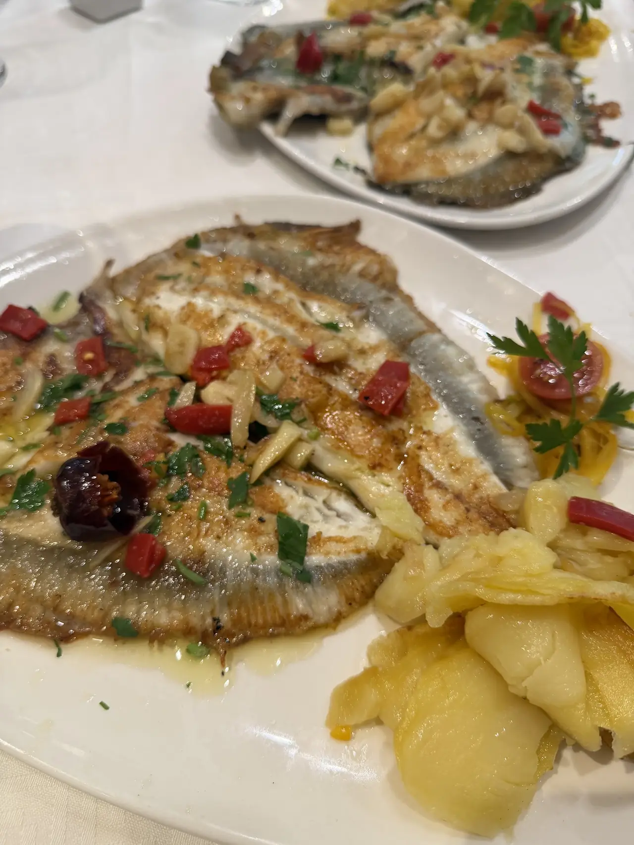 Grilled whole flatfish topped with garlic, chili and parsley, served with potatoes