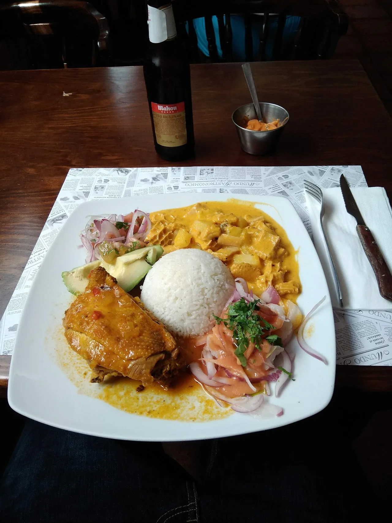 A plate of rice with fried chicken, avocado, and pickled onion