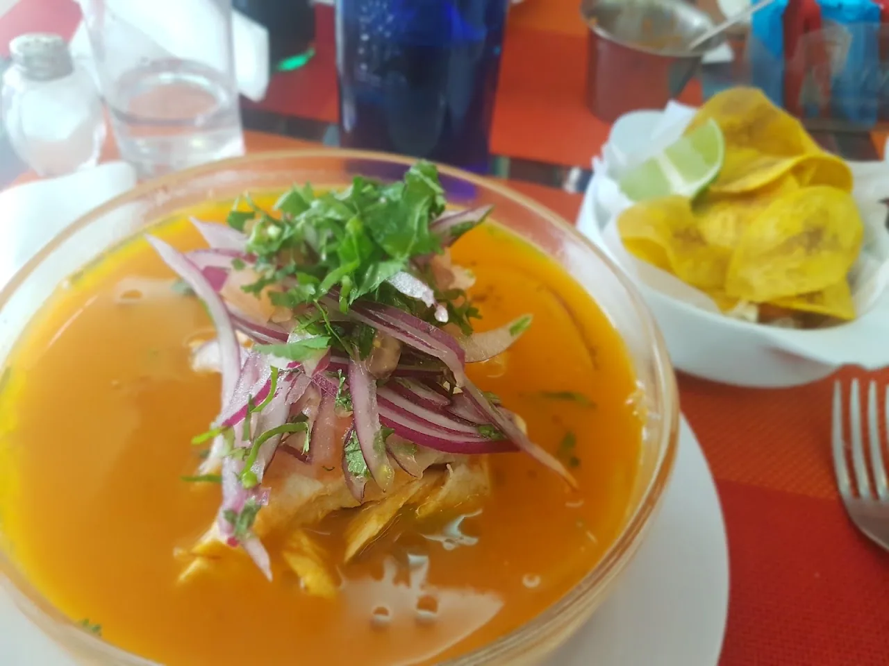 A ceviche bowl with plantain chips and fried yuca