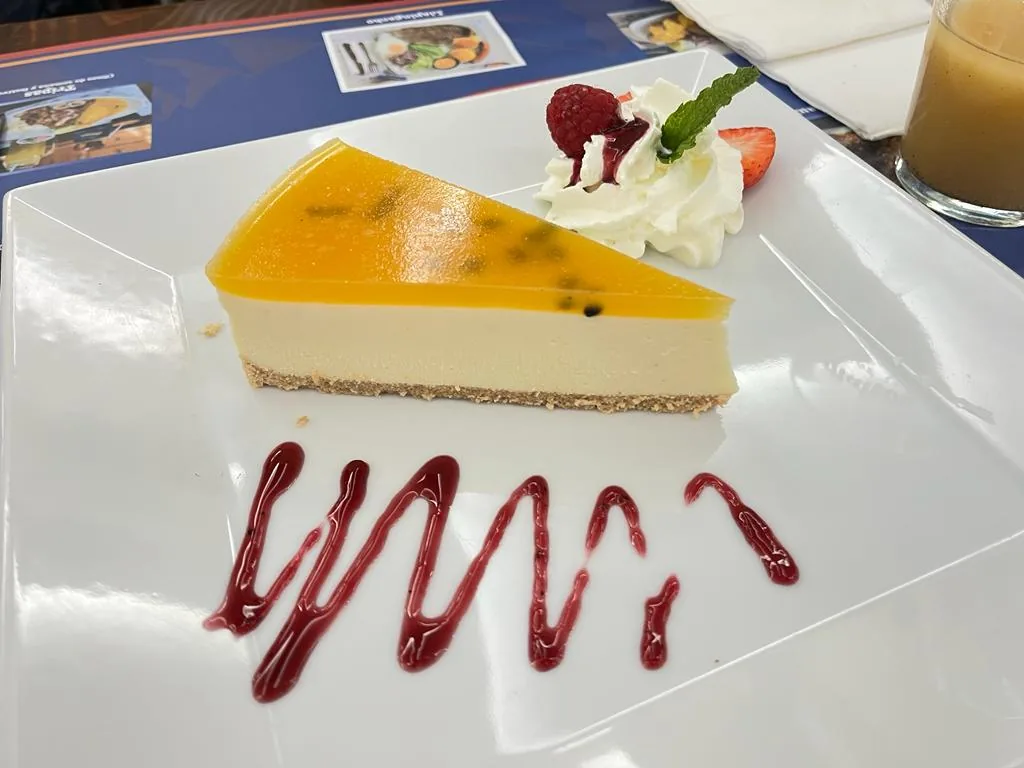 A slice of cheesecake with passion fruit sauce