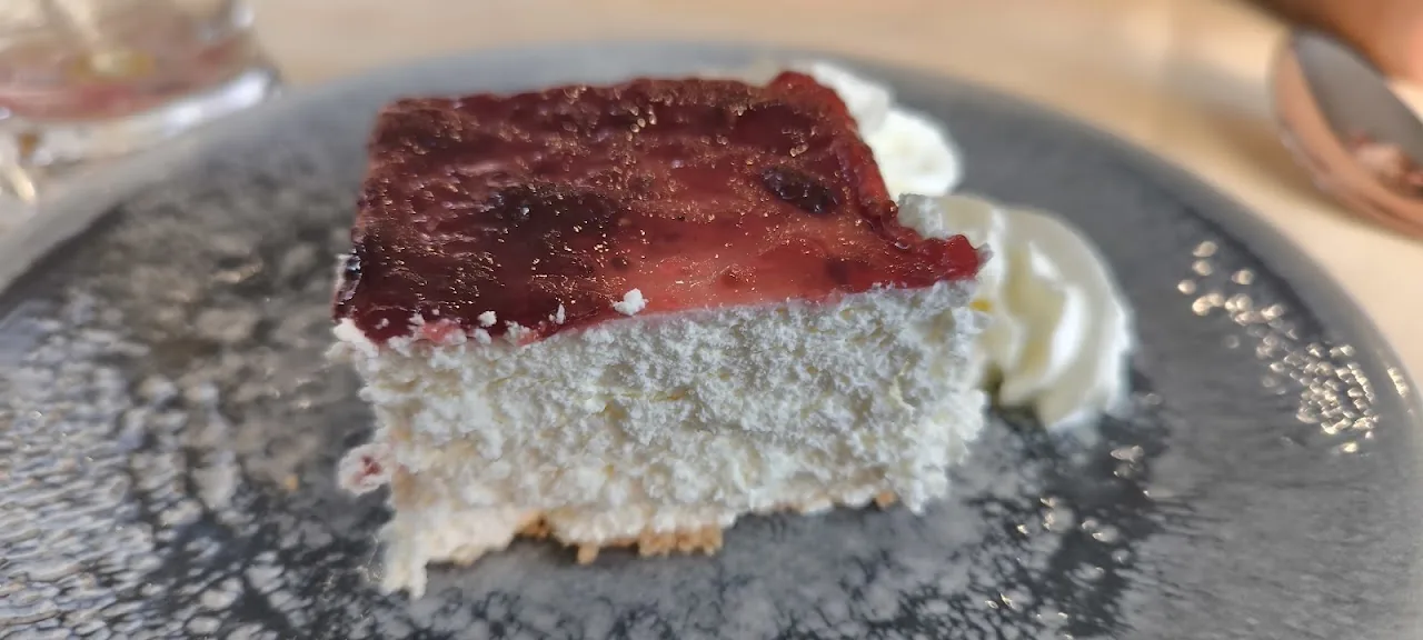 A slice of cheesecake with red berry topping
