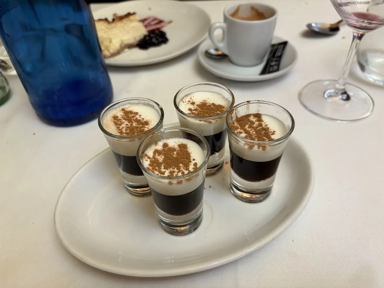 Four layered coffee and cream dessert shots with coffee